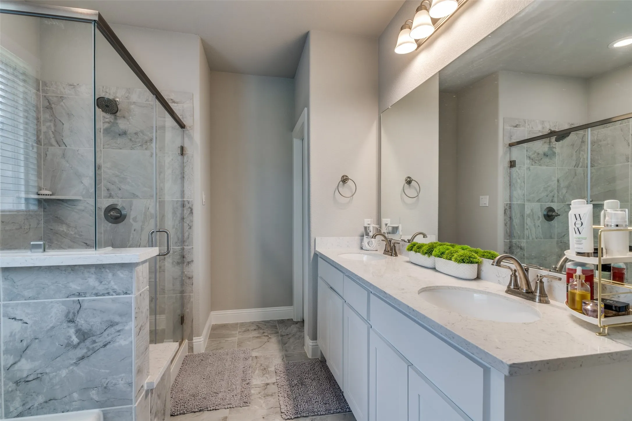 Bathroom featuring a dual vanity with undermount sinks, light-toned countertops, and brushed nickel fixtures