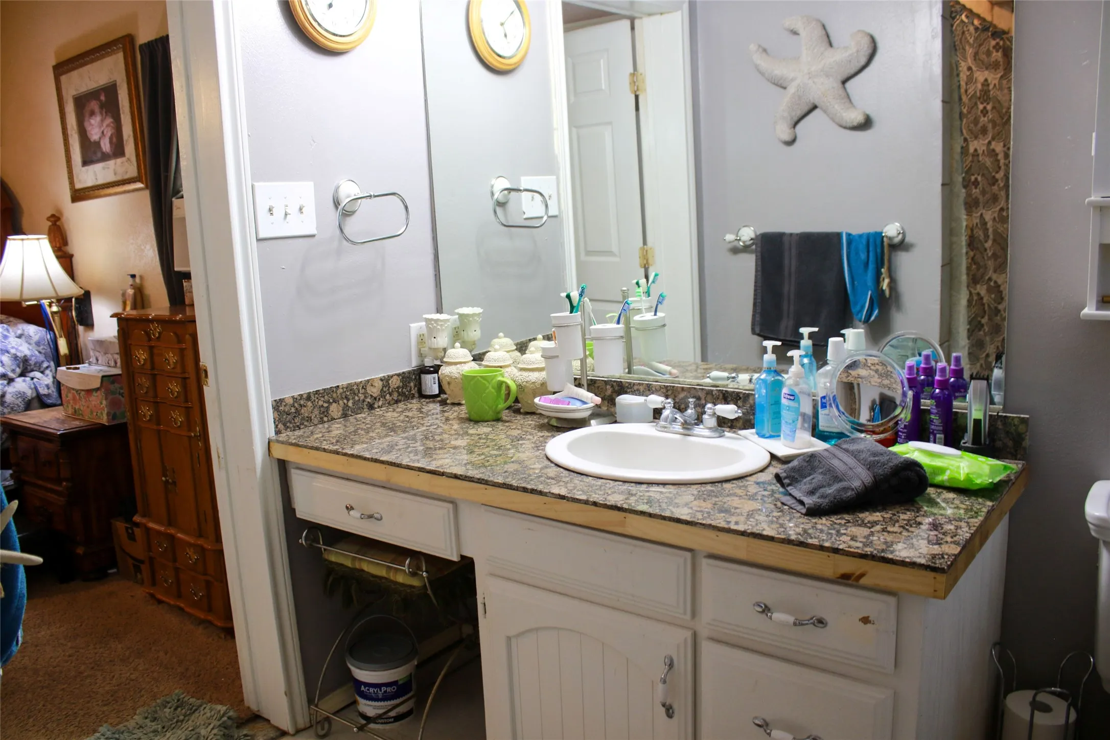 Vanity with a built-in sink, stone-finish countertop, and white cabinetry