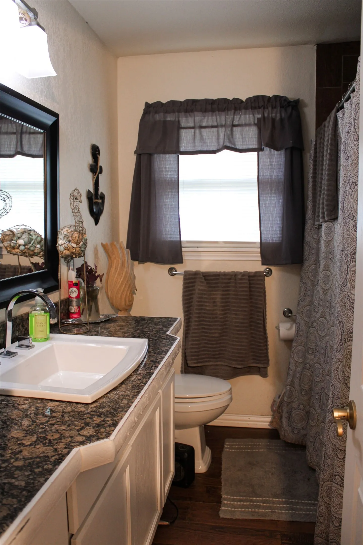 Bathroom featuring a vanity with a dark speckled countertop and white under-mount sink