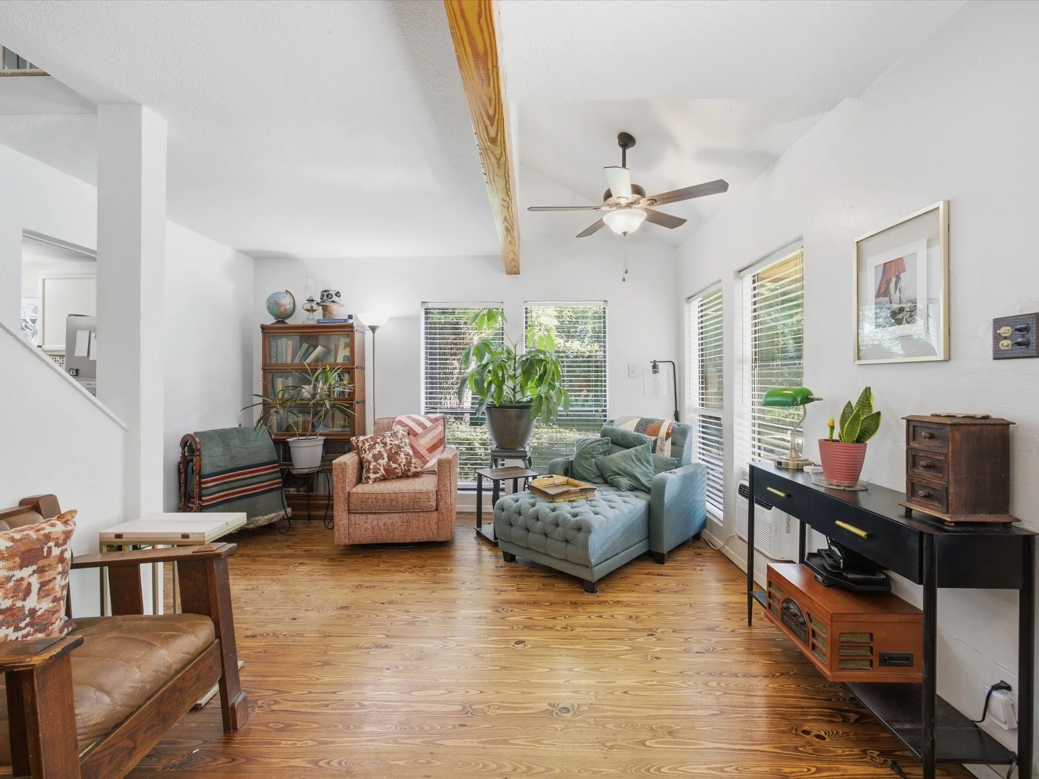 Spacious living area featuring wood-finish flooring, vaulted ceilings, and exposed wood beams