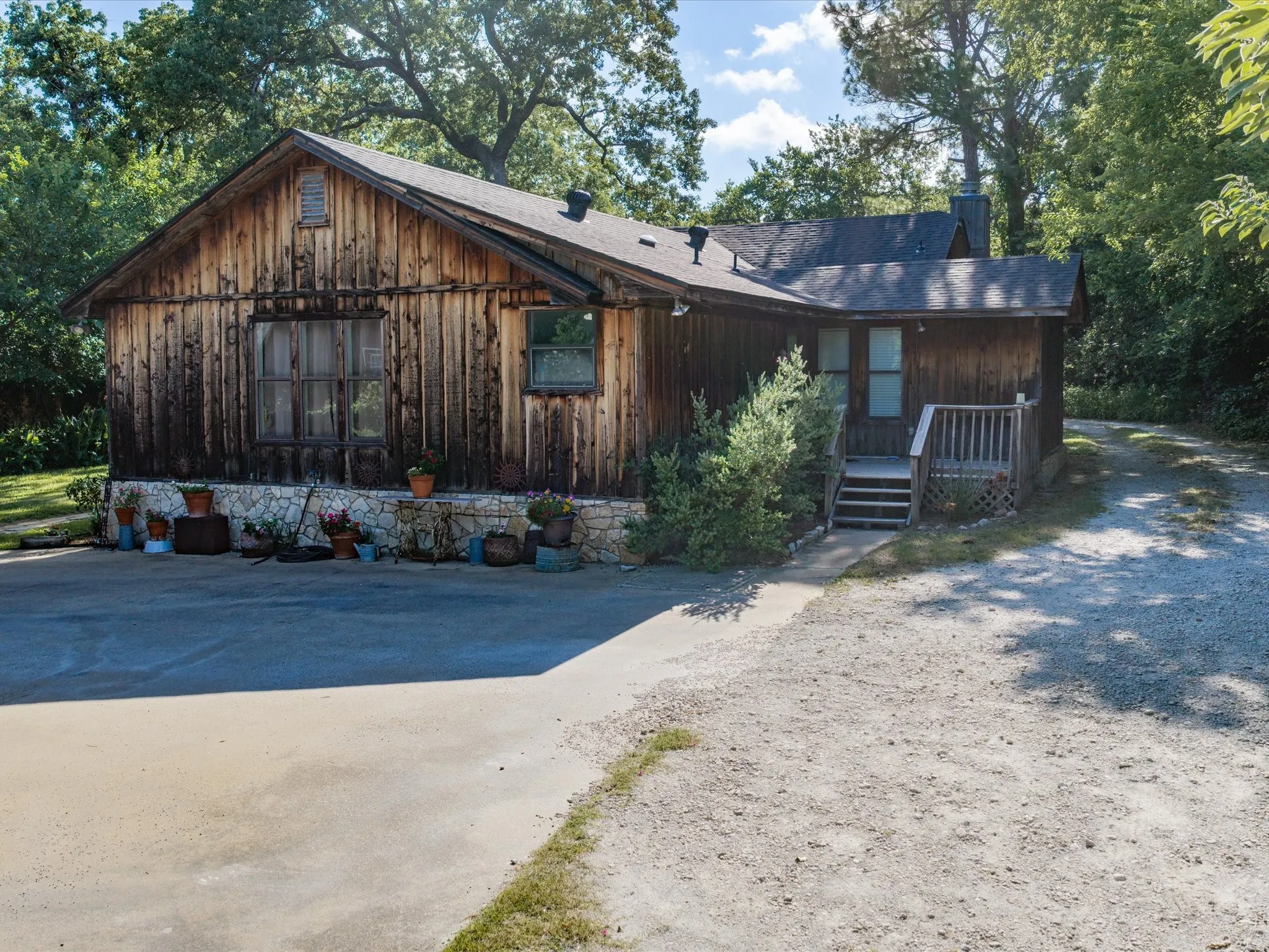 Wood-sided exterior featuring a stone foundation and a gabled roofline