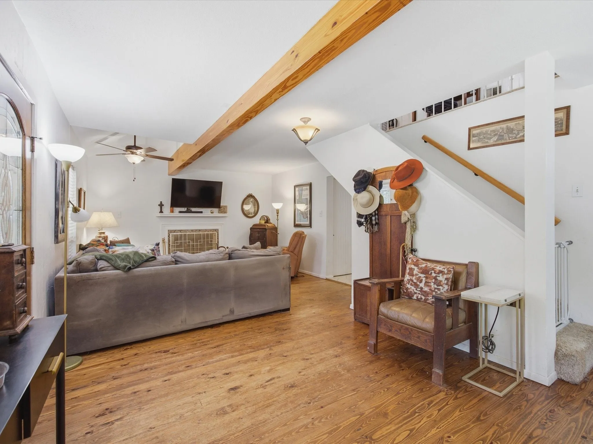 Spacious living area featuring wood-finish flooring and an exposed beam ceiling