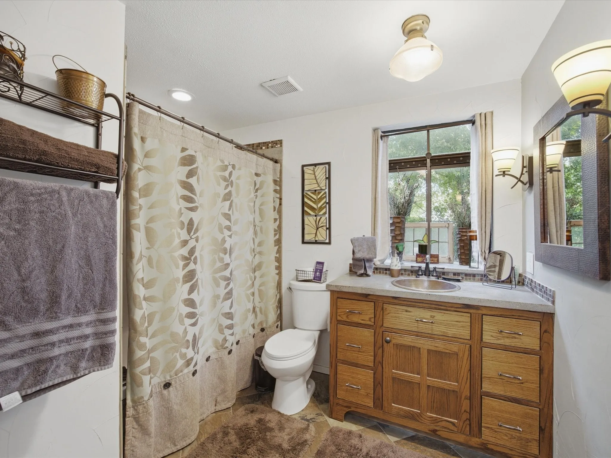 Bathroom vanity featuring wood cabinetry, a built-in sink, and a light-toned countertop