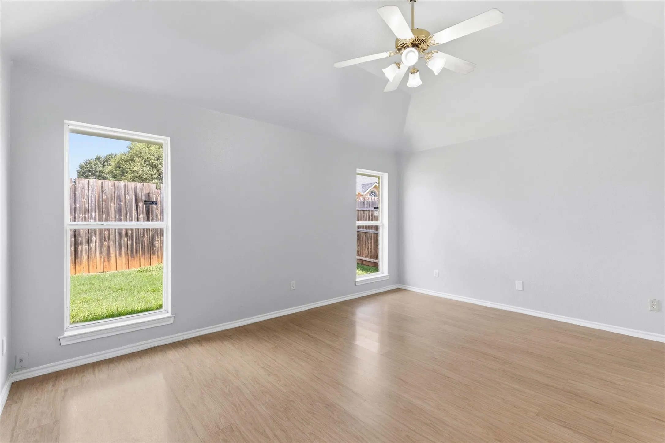 Vaulted ceiling with a brass-finish ceiling fan and light fixture