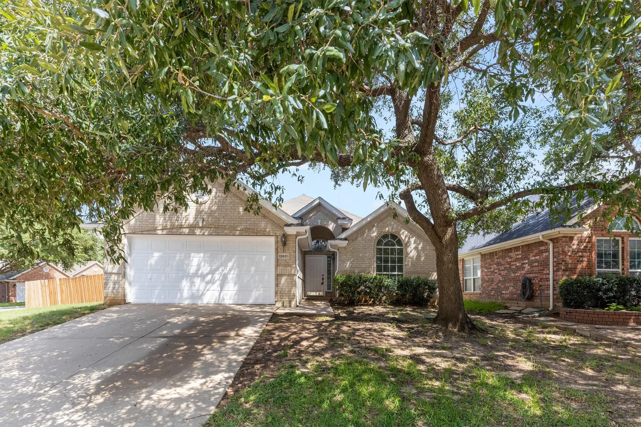 Traditional single-story residence featuring a light brick facade and a two-car garage