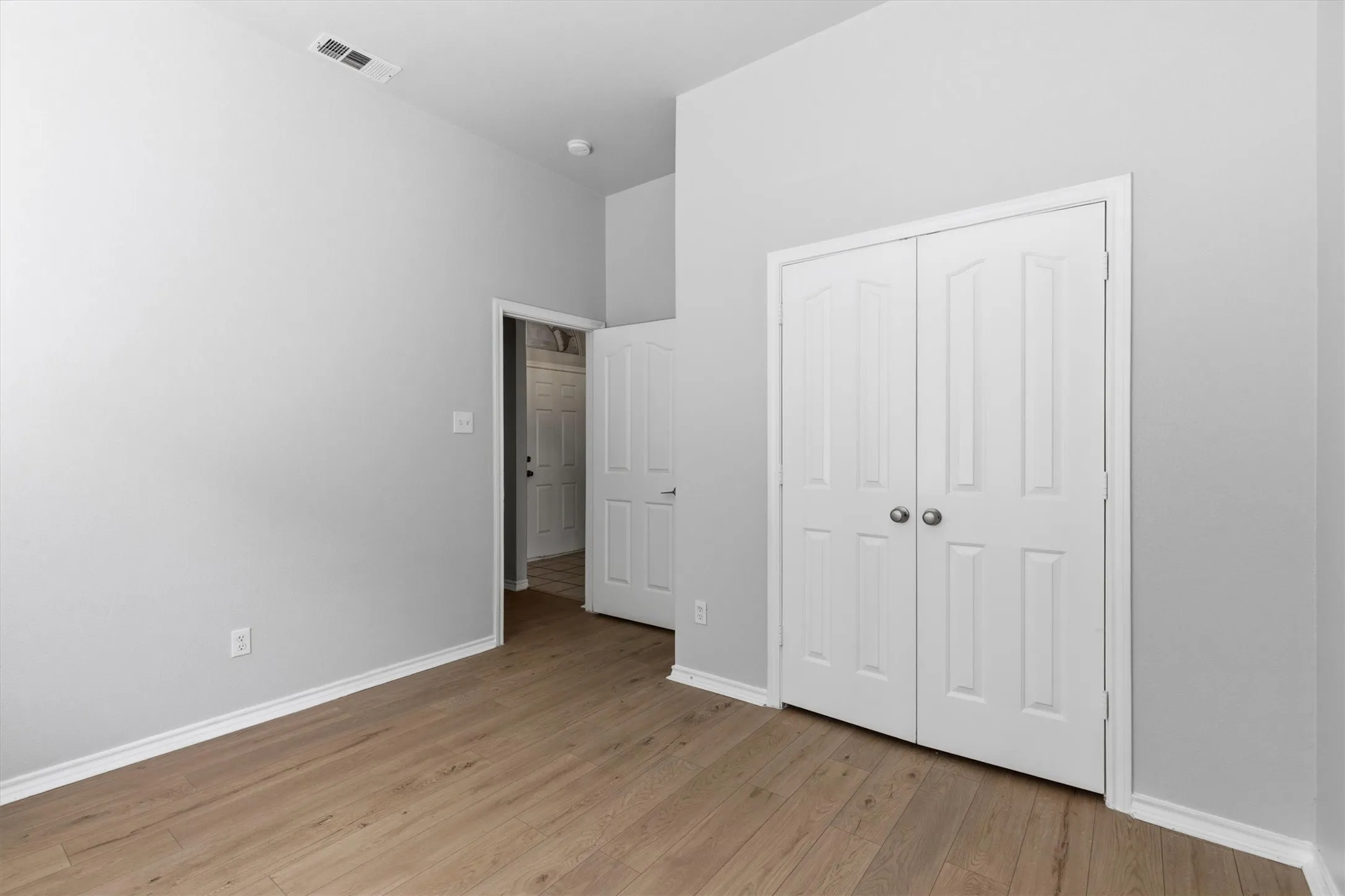 Interior room featuring wood-finish flooring and light gray walls