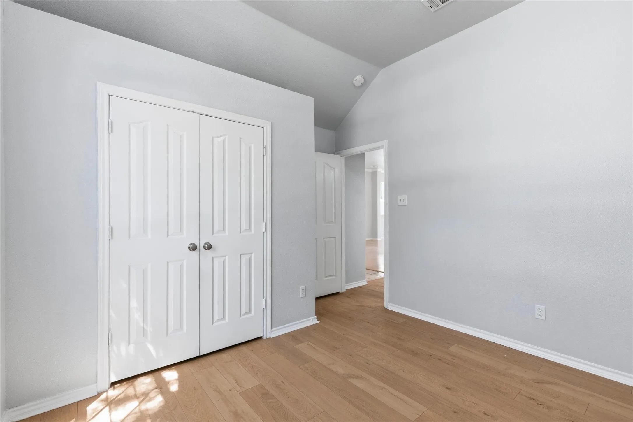 Light wood-finish flooring with white baseboards throughout