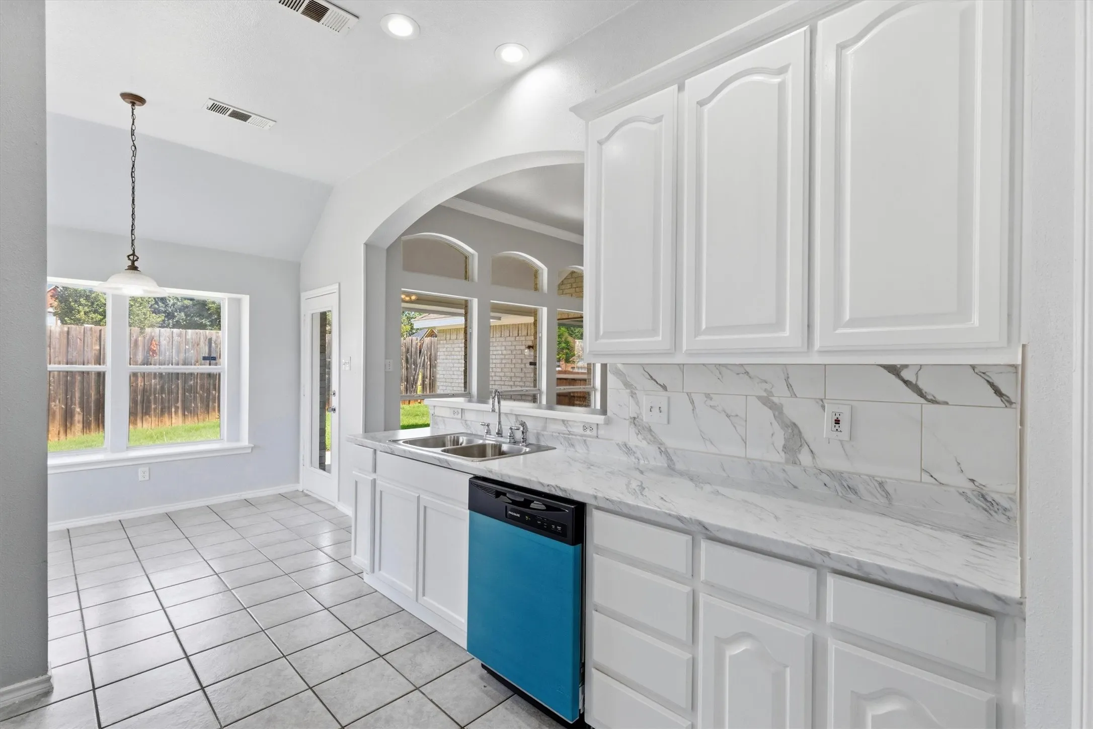 Kitchen featuring white cabinetry, a double basin sink, and a black dishwasher