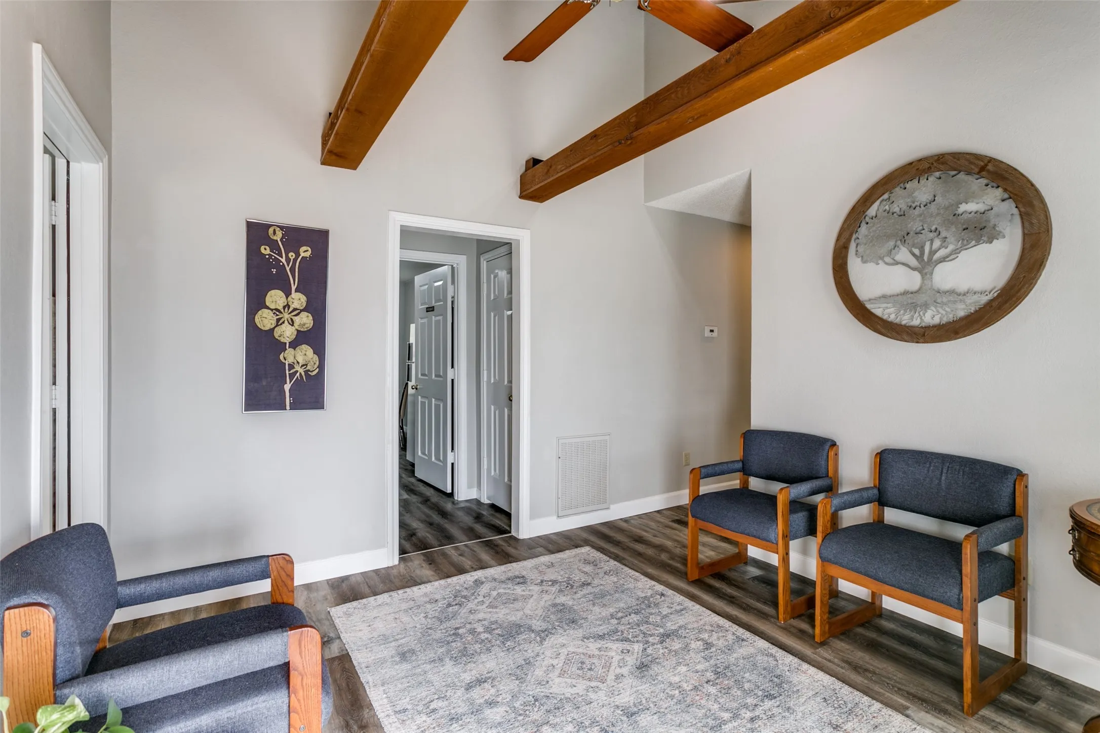 Vaulted ceilings featuring exposed wood beams, wood-finish flooring, and light gray wall paint
