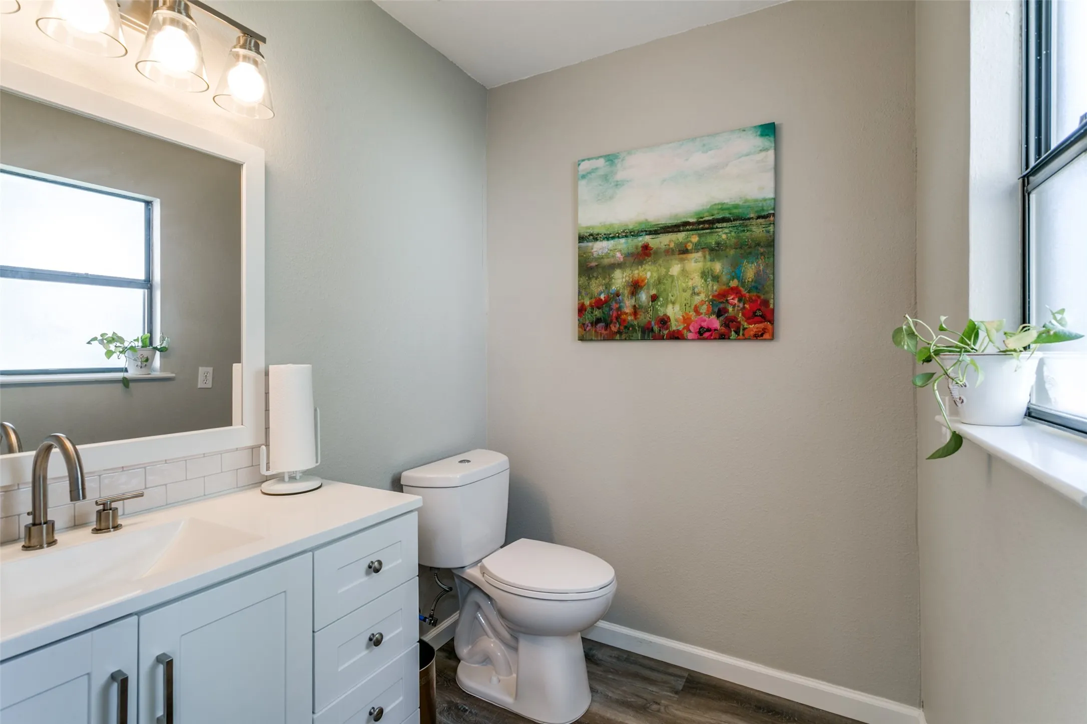 Bathroom featuring a single vanity with white cabinetry, a white countertop, and a subway tile backsplash