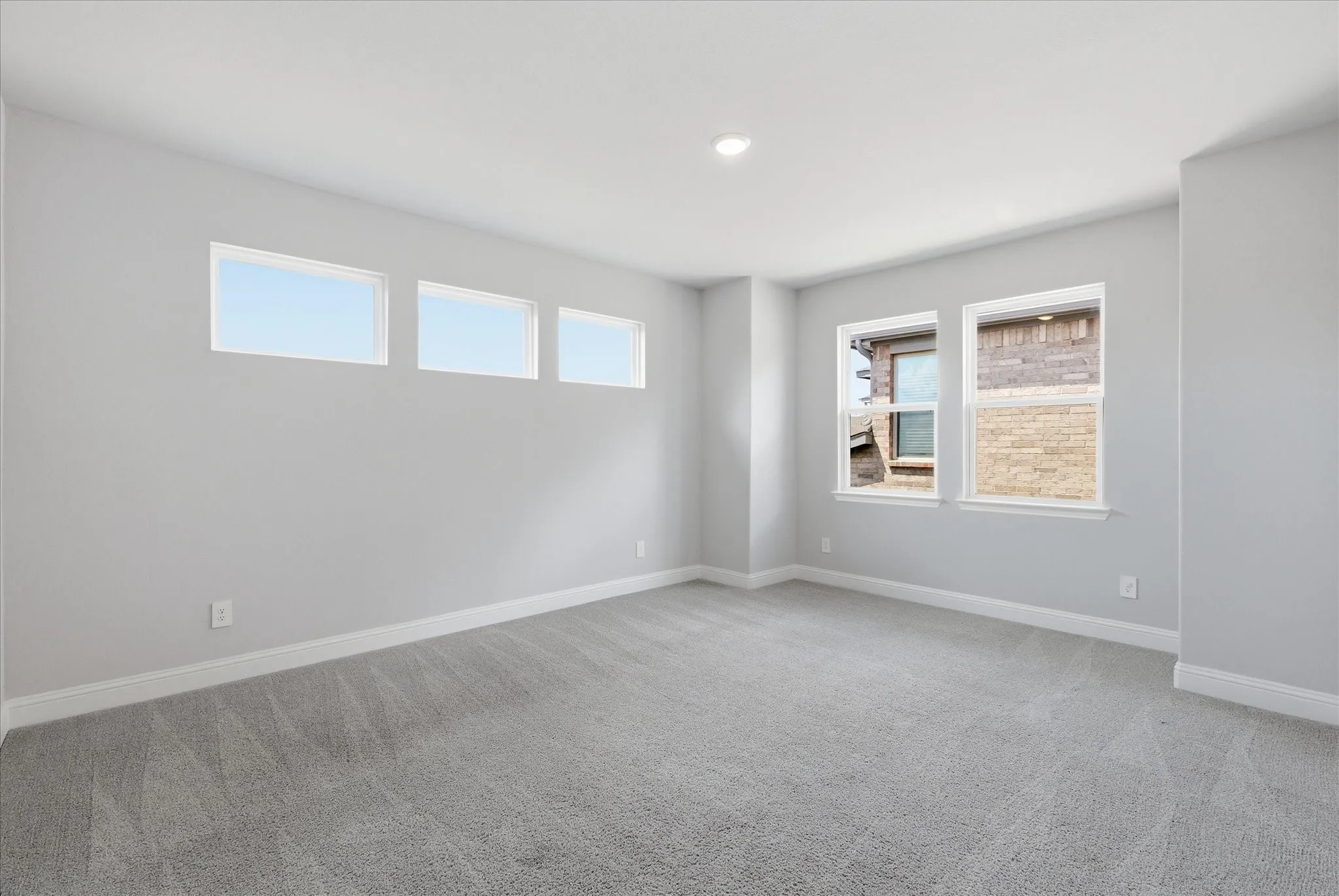 Carpeted room featuring multiple windows, recessed lighting, and crisp white trim