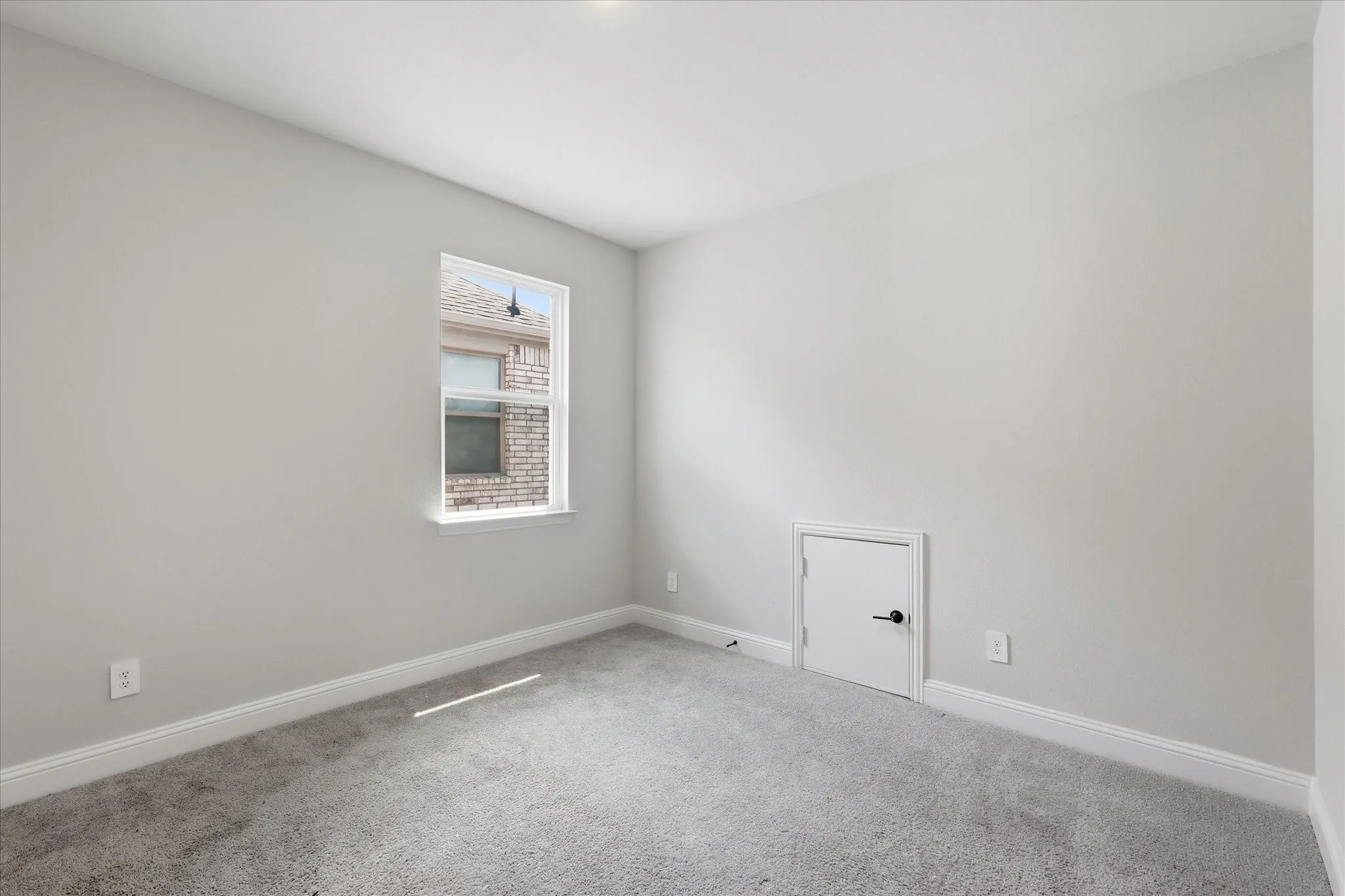 Room featuring light gray walls, gray carpet, white baseboards, and a single window with white trim