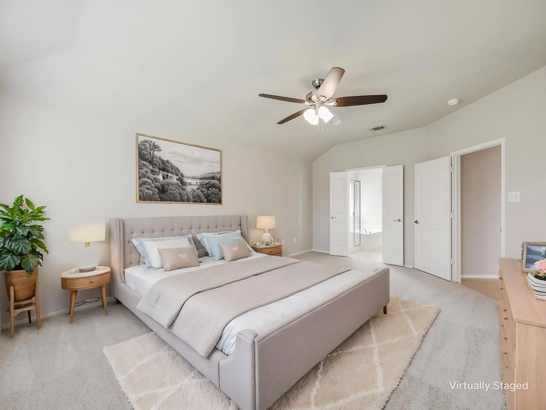 Virtually staged - Spacious sleeping area featuring vaulted ceilings, neutral carpeting, and a ceiling fan with integrated lighting