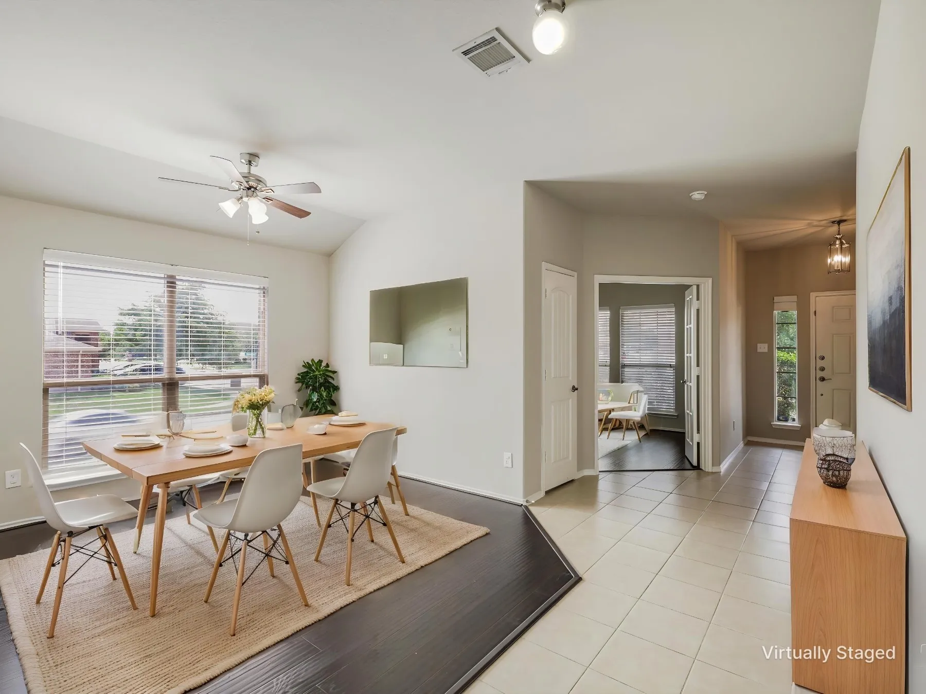 Virtually staged - Open-concept dining area featuring wood-finish flooring, a vaulted ceiling, and a ceiling fan with integrated lighting