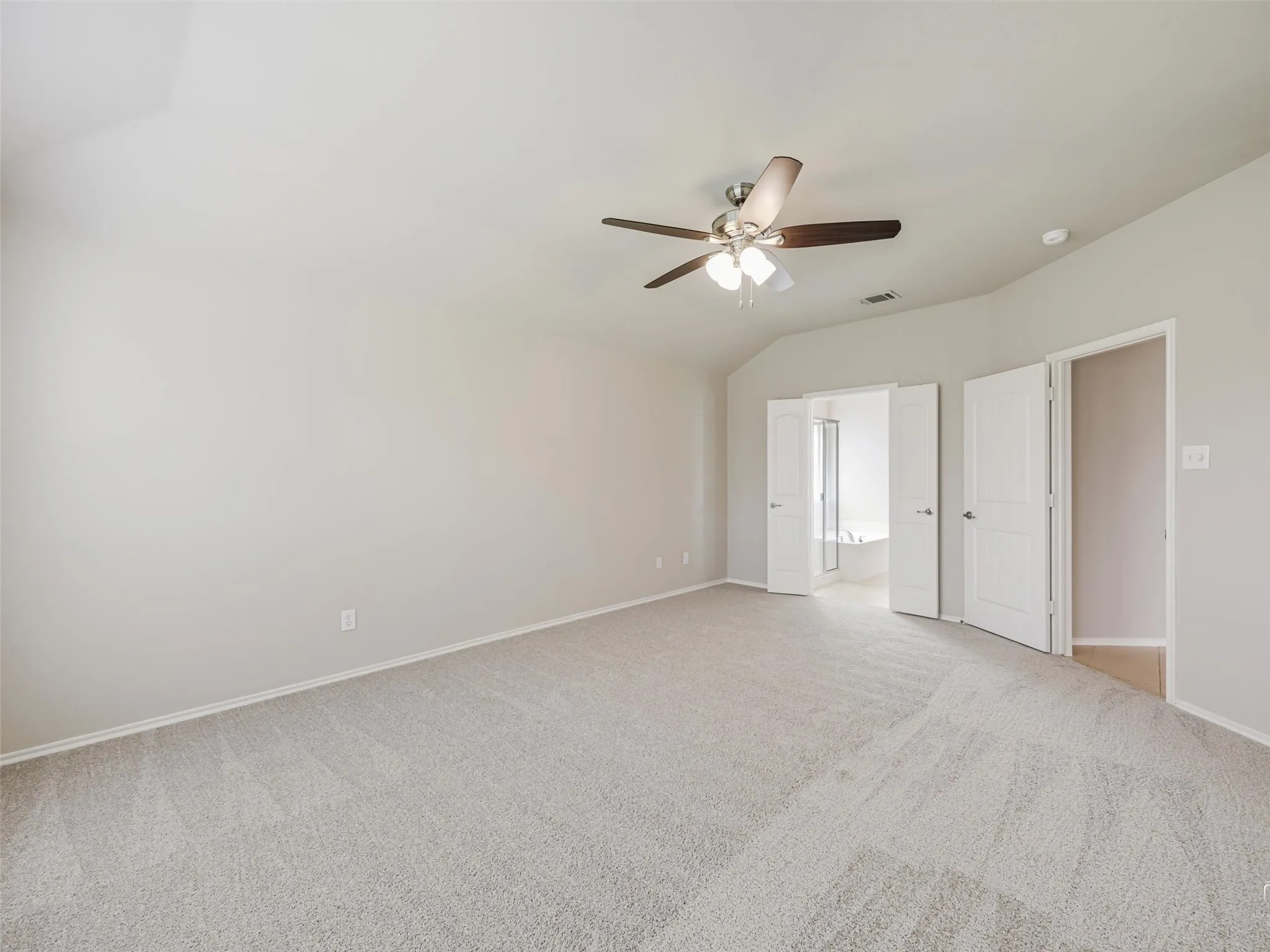 Spacious room with light gray carpeting and neutral wall paint