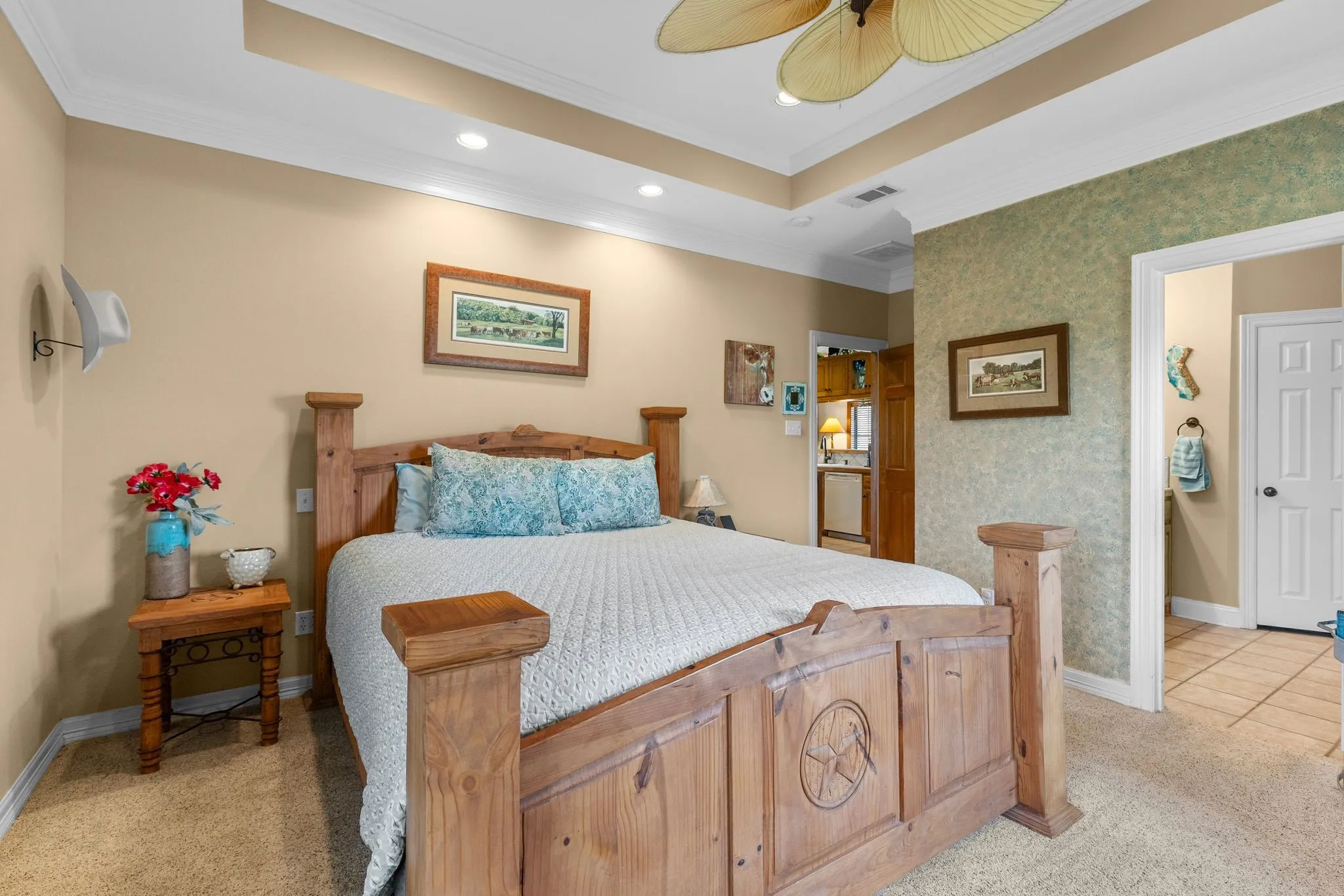 Carpeted bedroom featuring a tray ceiling with recessed lighting and a ceiling fan