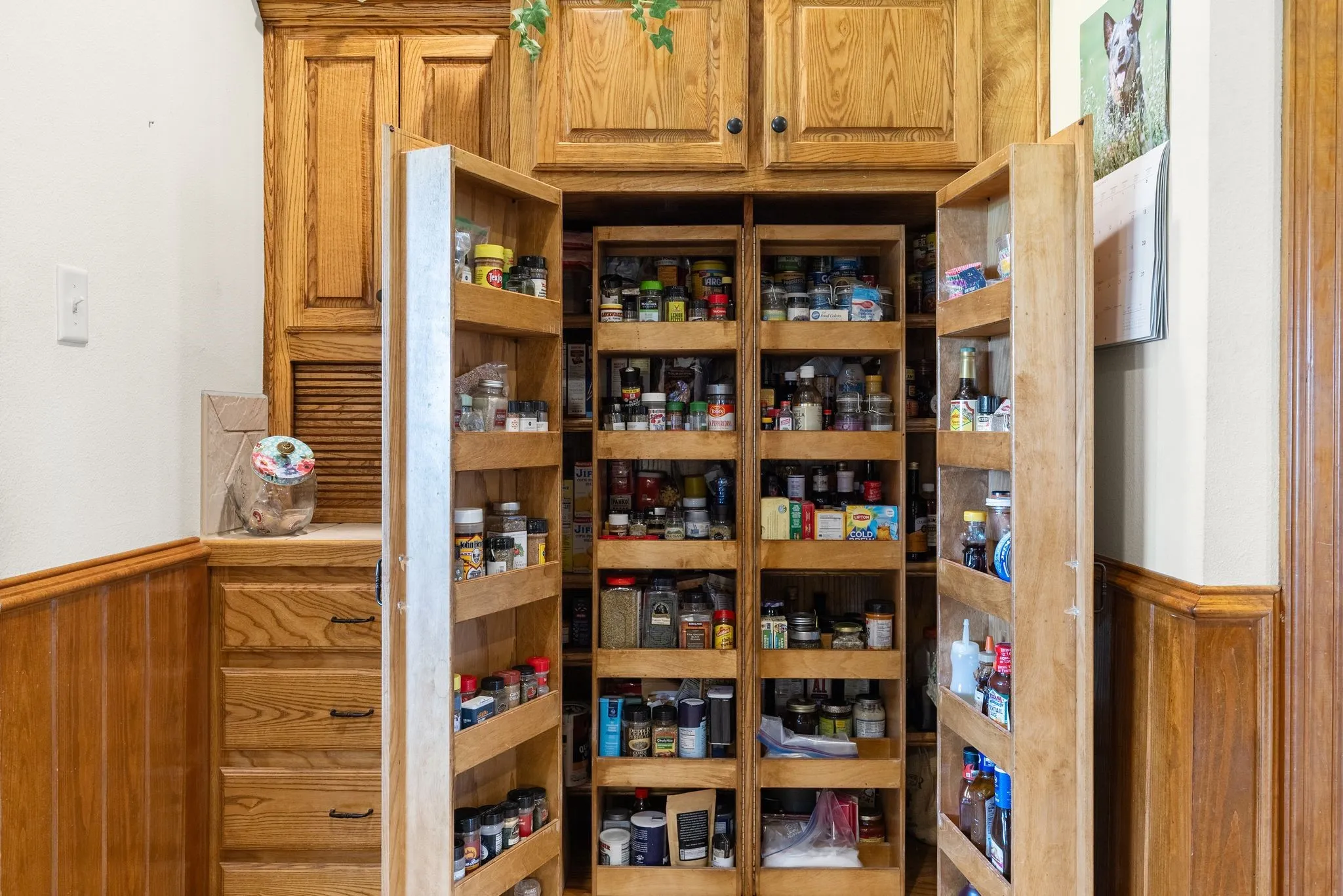 Custom-built oak pantry featuring pull-out spice racks and extensive shelving