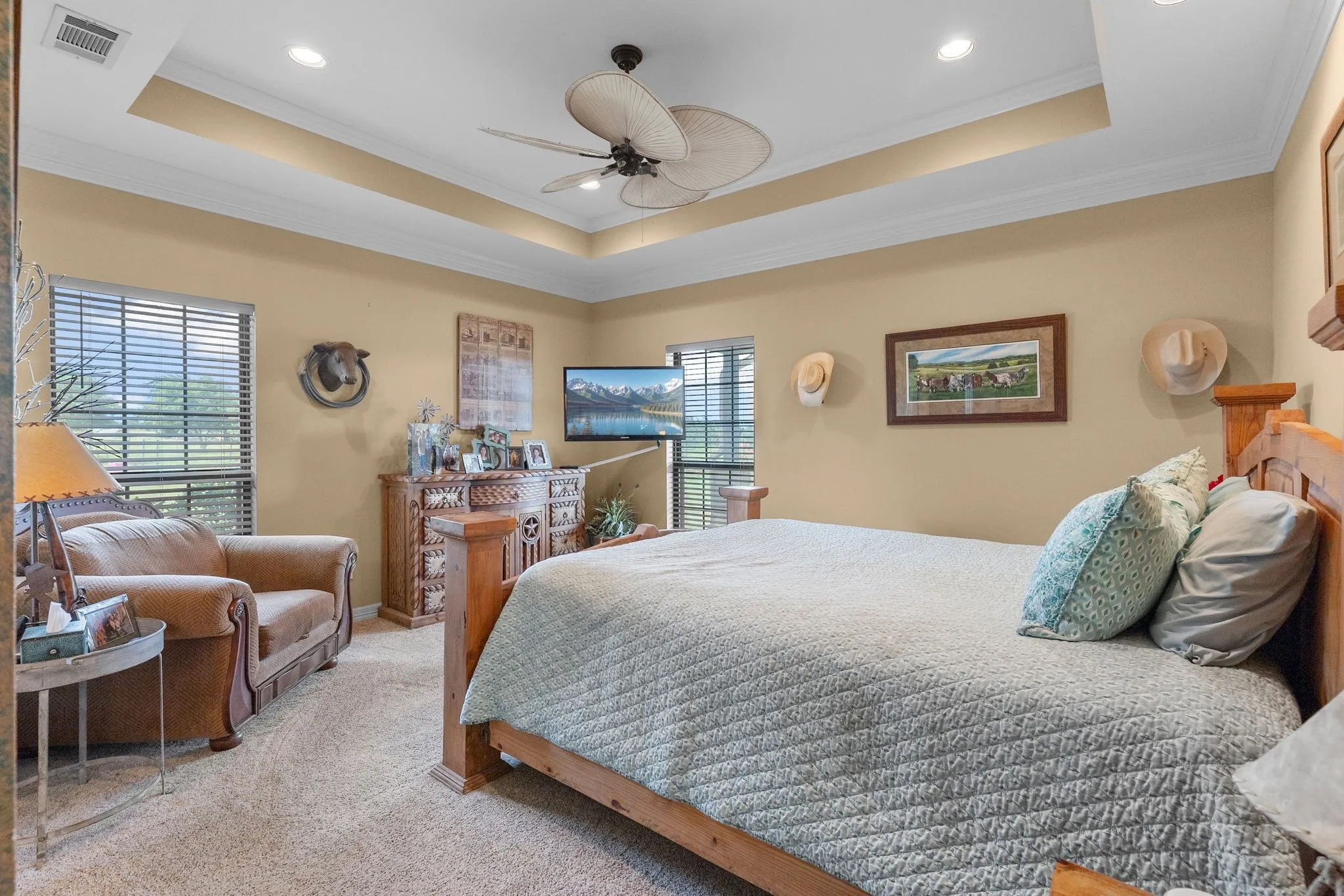 Recessed lighting illuminates a tray ceiling with a ceiling fan