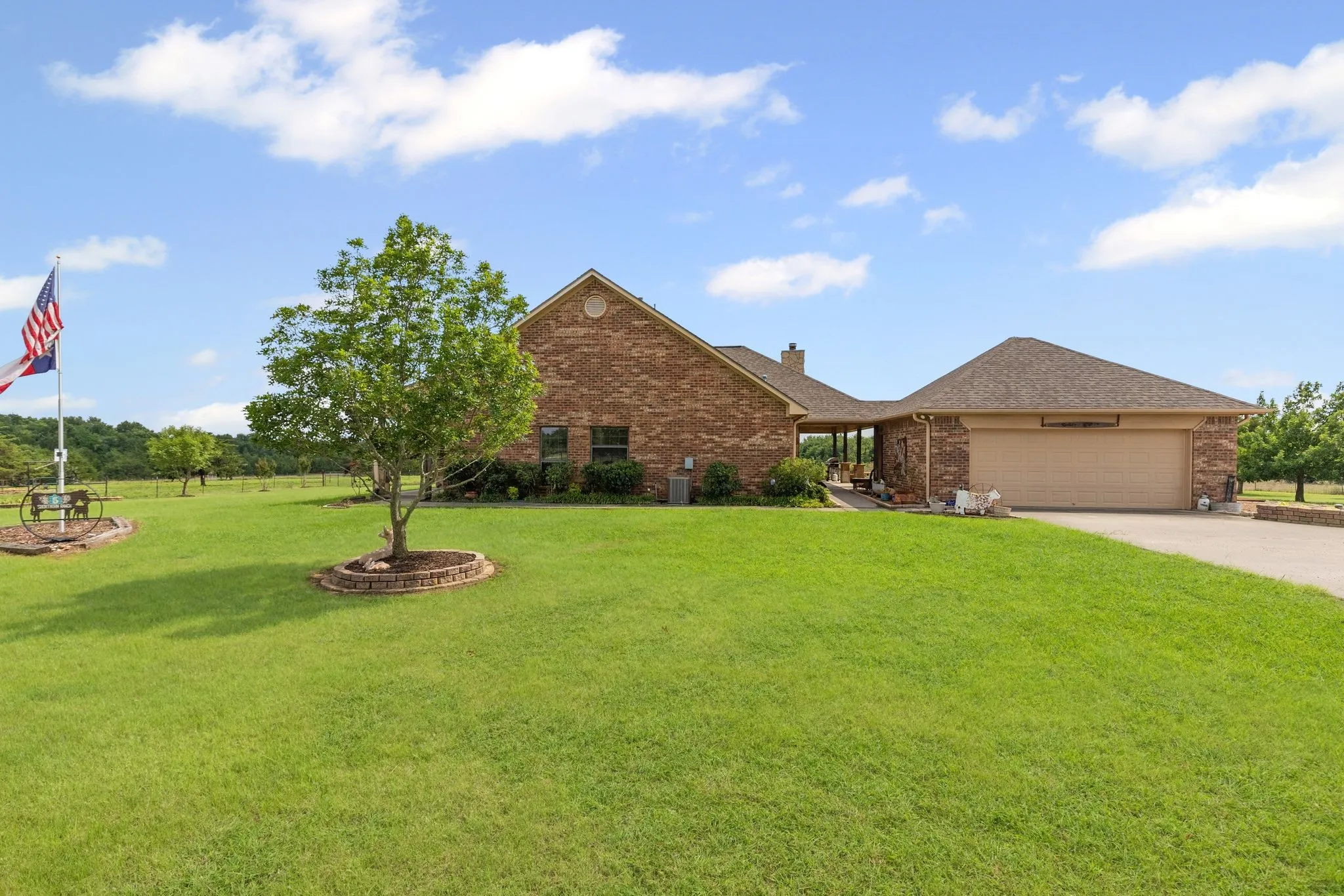 Brick exterior with an attached garage and expansive green lawn