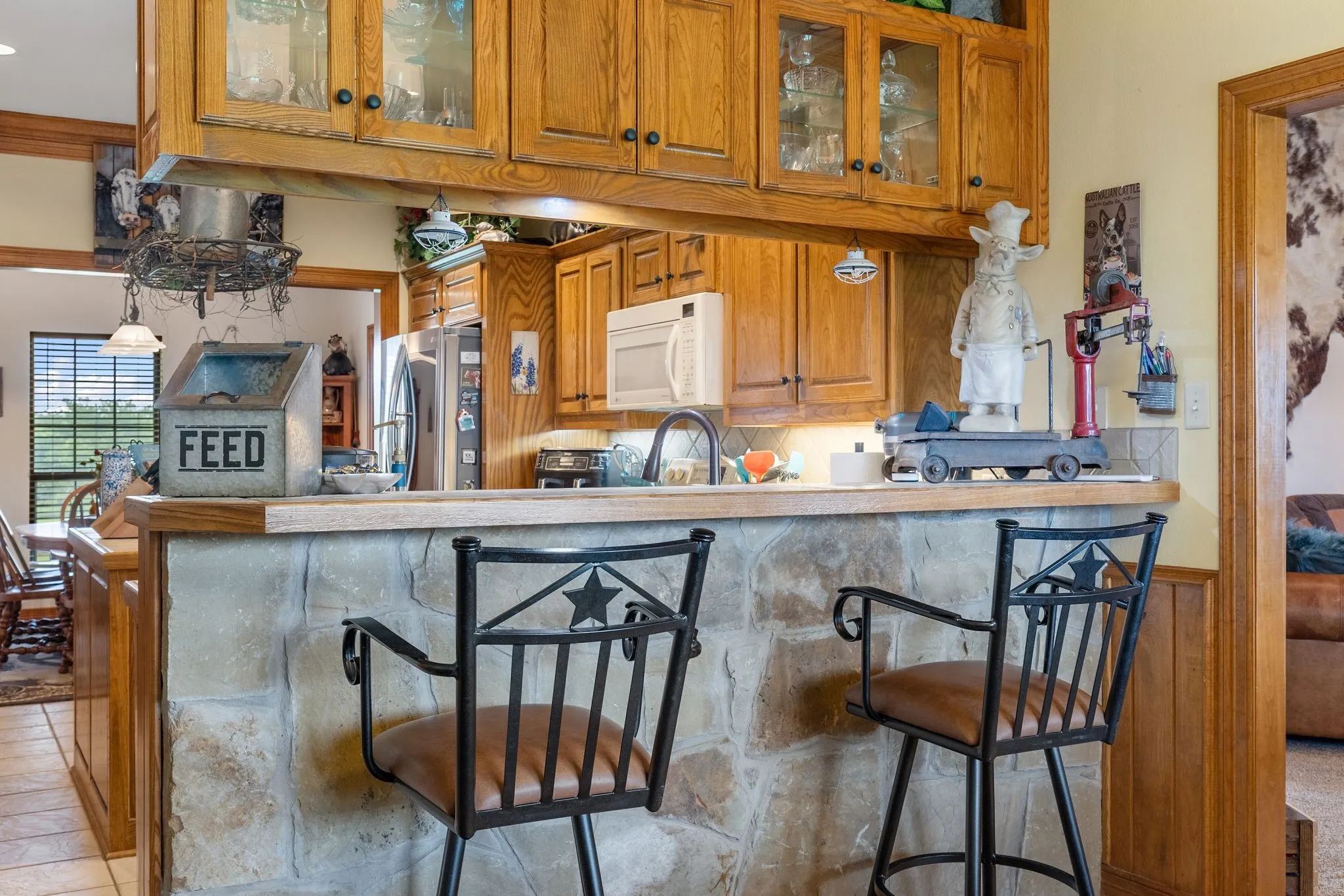 Kitchen featuring a stone-clad breakfast bar with a wood-finish countertop
