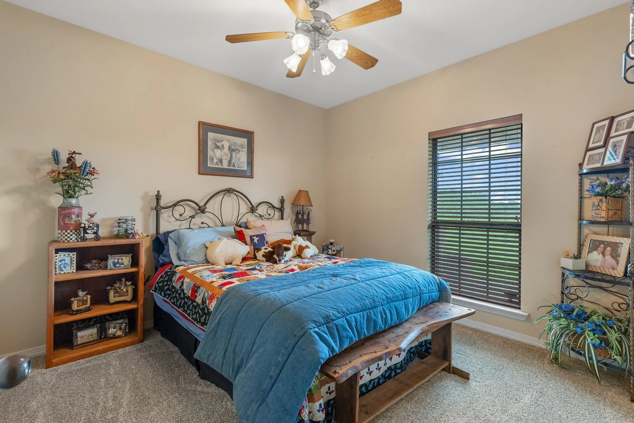 Secondary bedroom room featuring a ceiling fan with light fixture, a window with horizontal blinds, and neutral wall paint