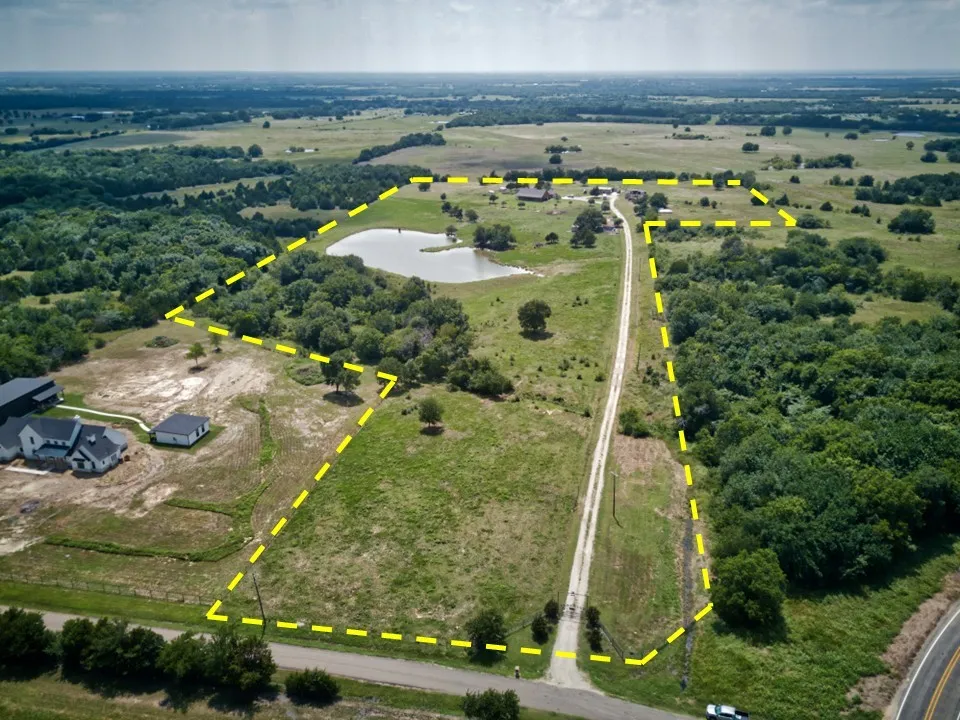 Expansive land parcel featuring a private pond, established treelines, a long private drive, and multiple clearings