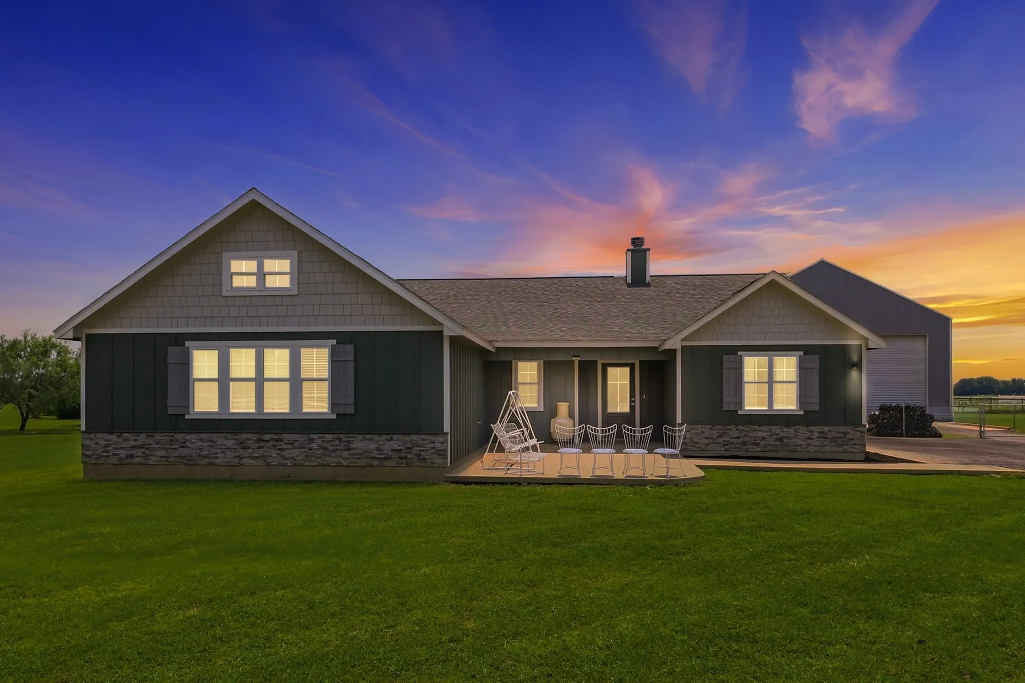 Exterior featuring dark siding, a light-toned stone facade, and a pitched roof