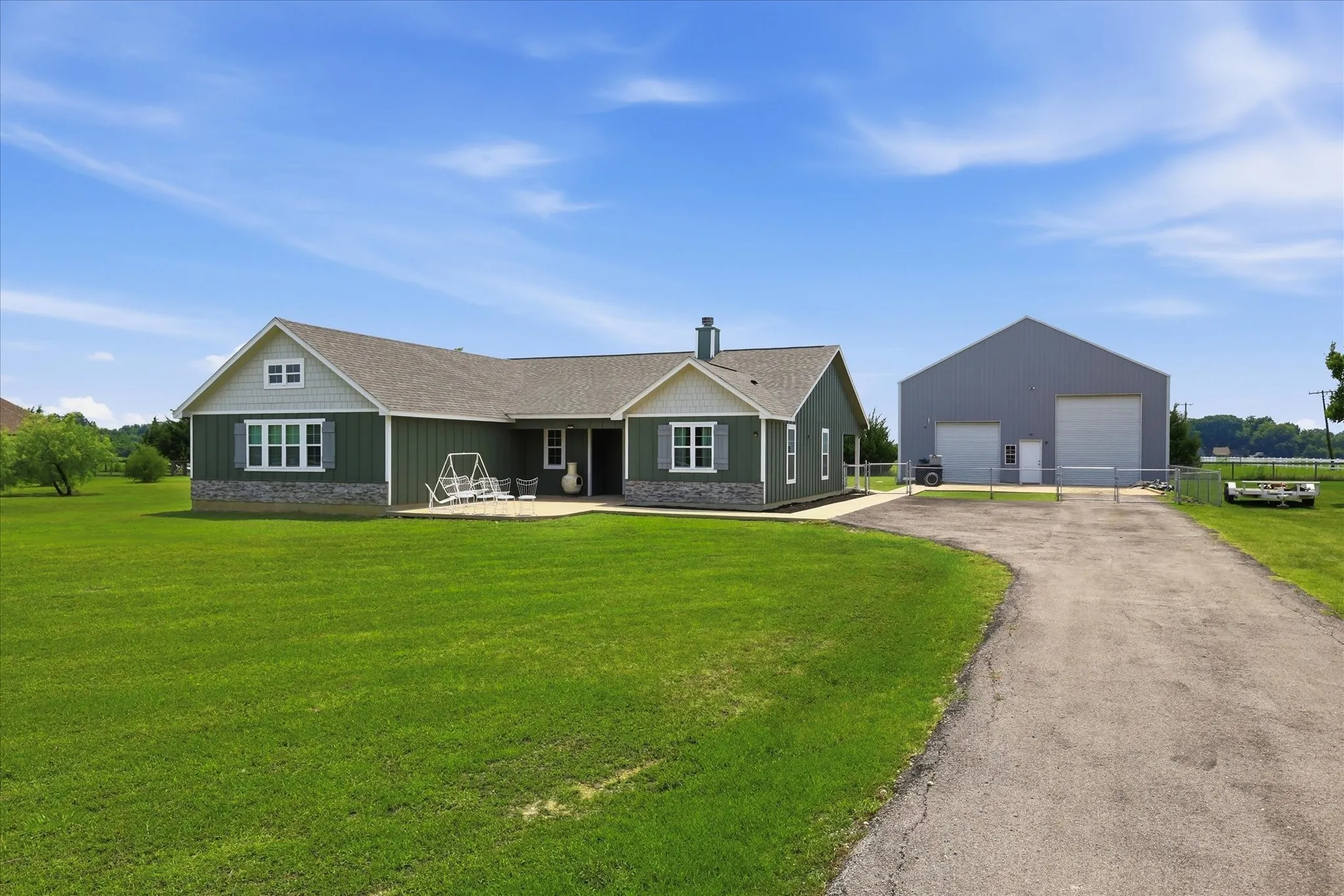 Ranch-style residence featuring a facade with light gray siding accents and a stone veneer foundation
