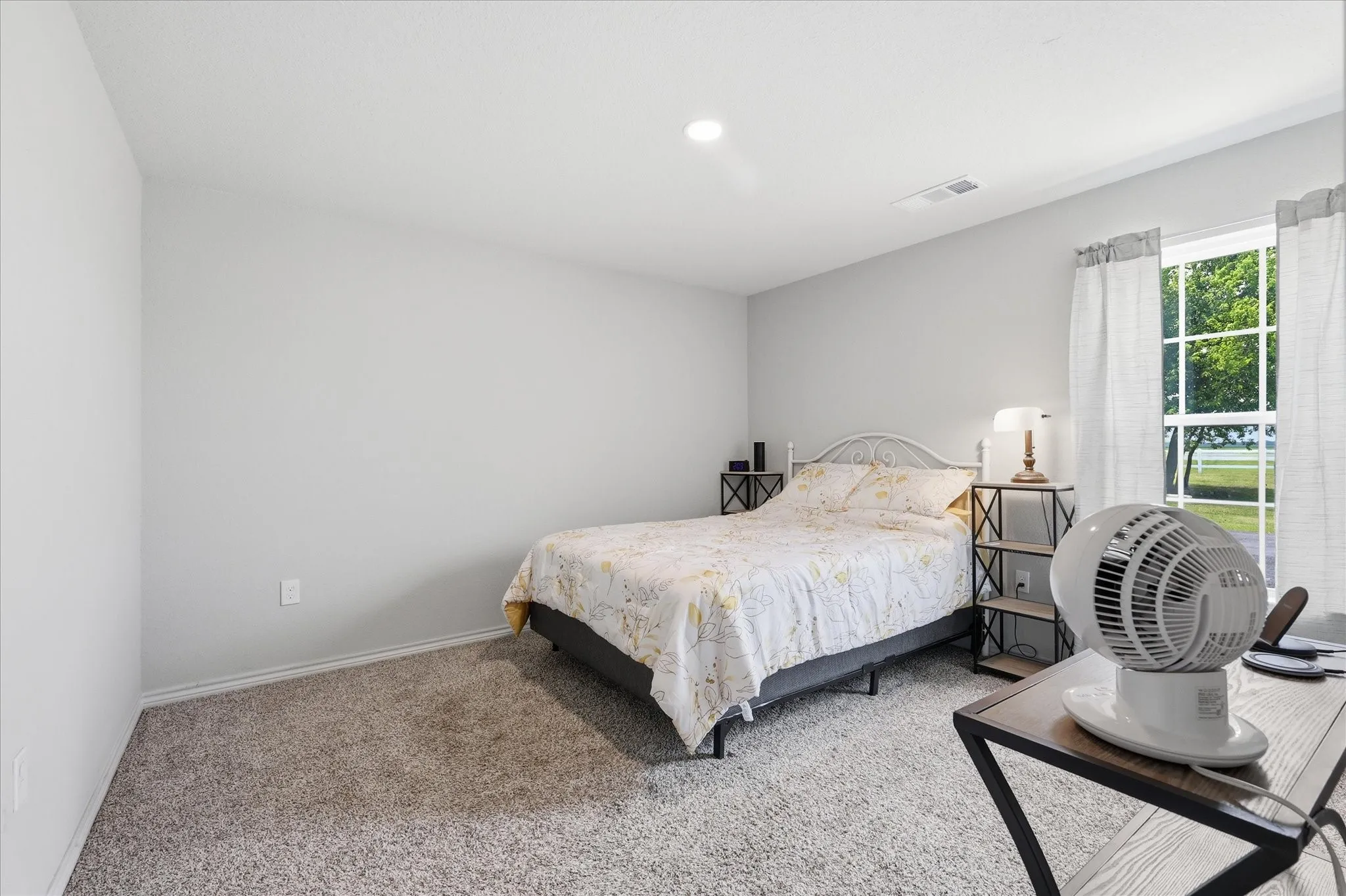 Carpeted room with a recessed ceiling light, white walls, and a window with white trim