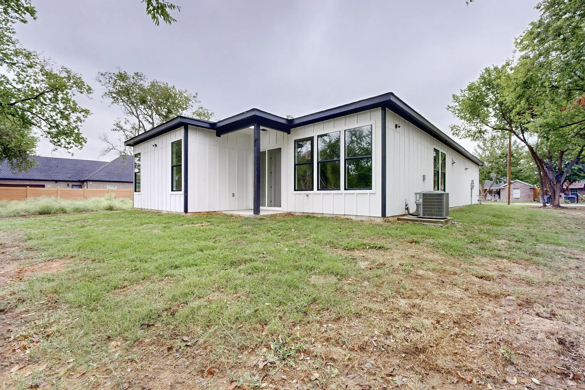 Modern exterior featuring vertical white siding and dark trim