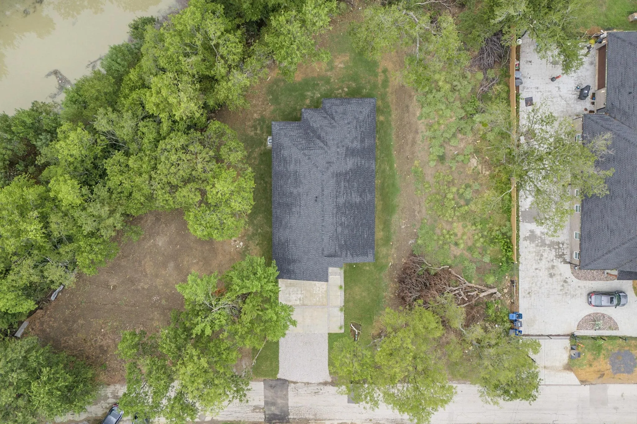 Detached single-family residence with a dark shingle roof and a concrete driveway