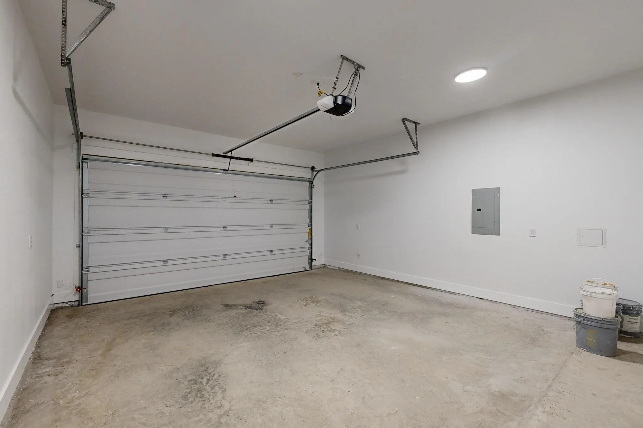 Spacious two-car garage featuring a sectional overhead door and automatic opener
