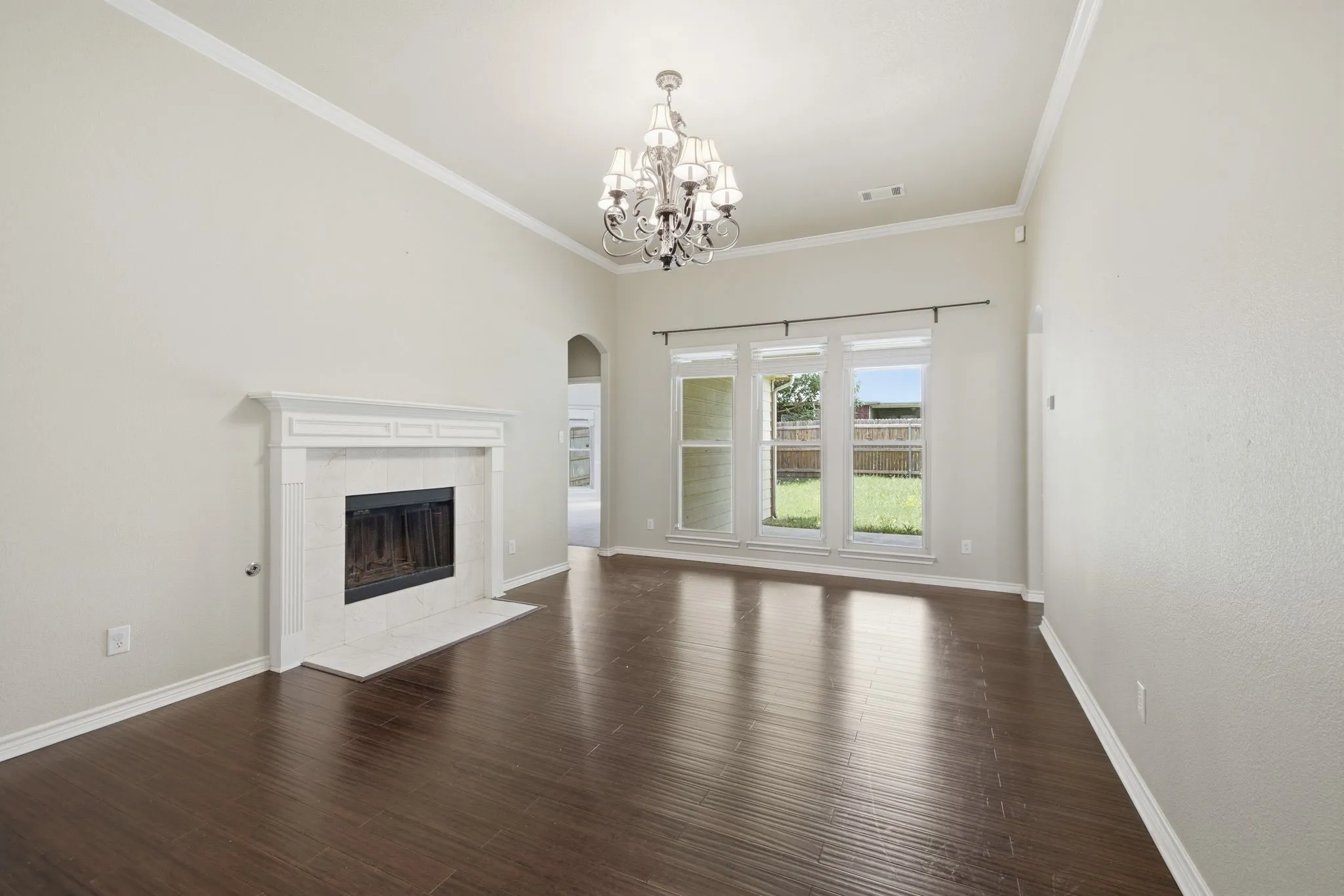 Large living space with fireplace and views to the covered patio and backyard.