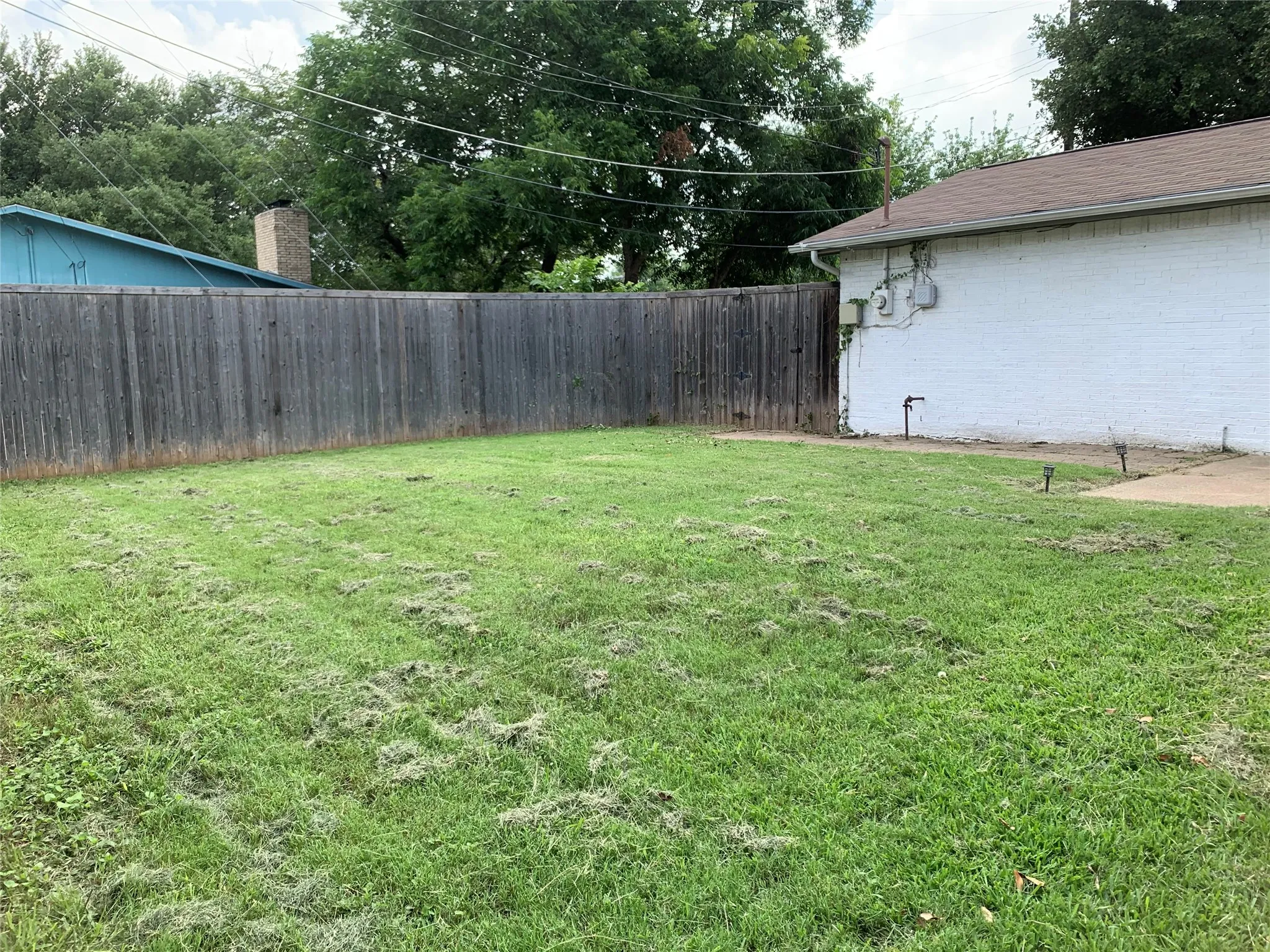 Expansive grassy area featuring a wood fence perimeter