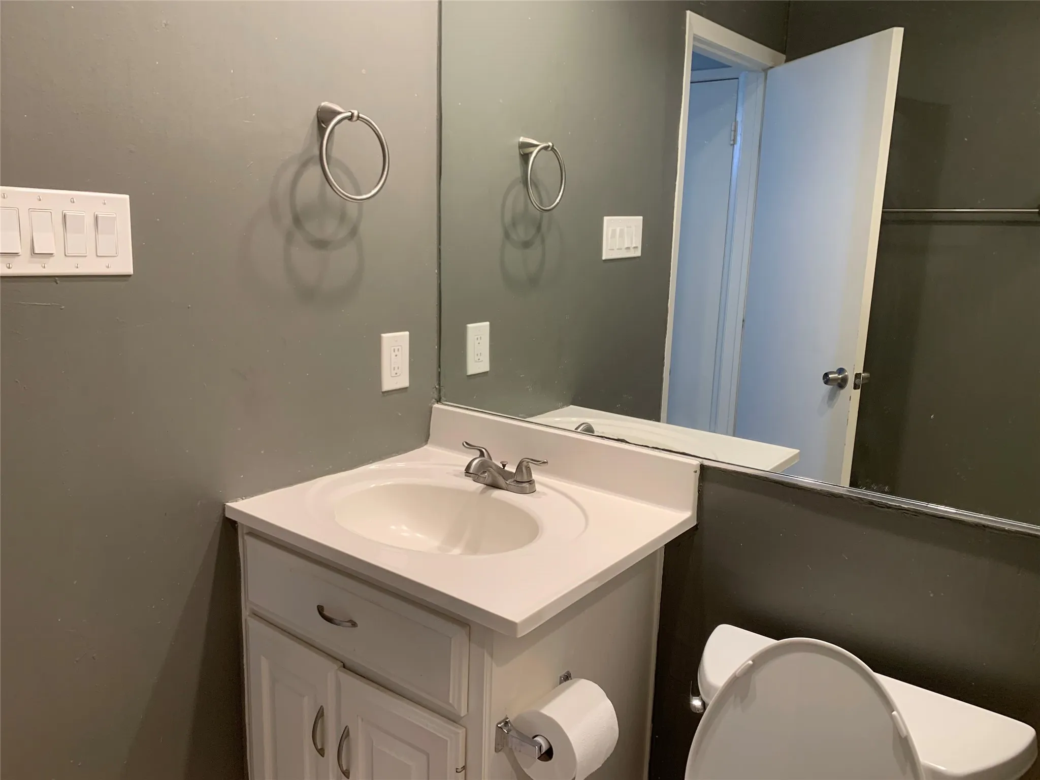 Bathroom vanity featuring an integrated sink, polished chrome faucet, and white cabinetry