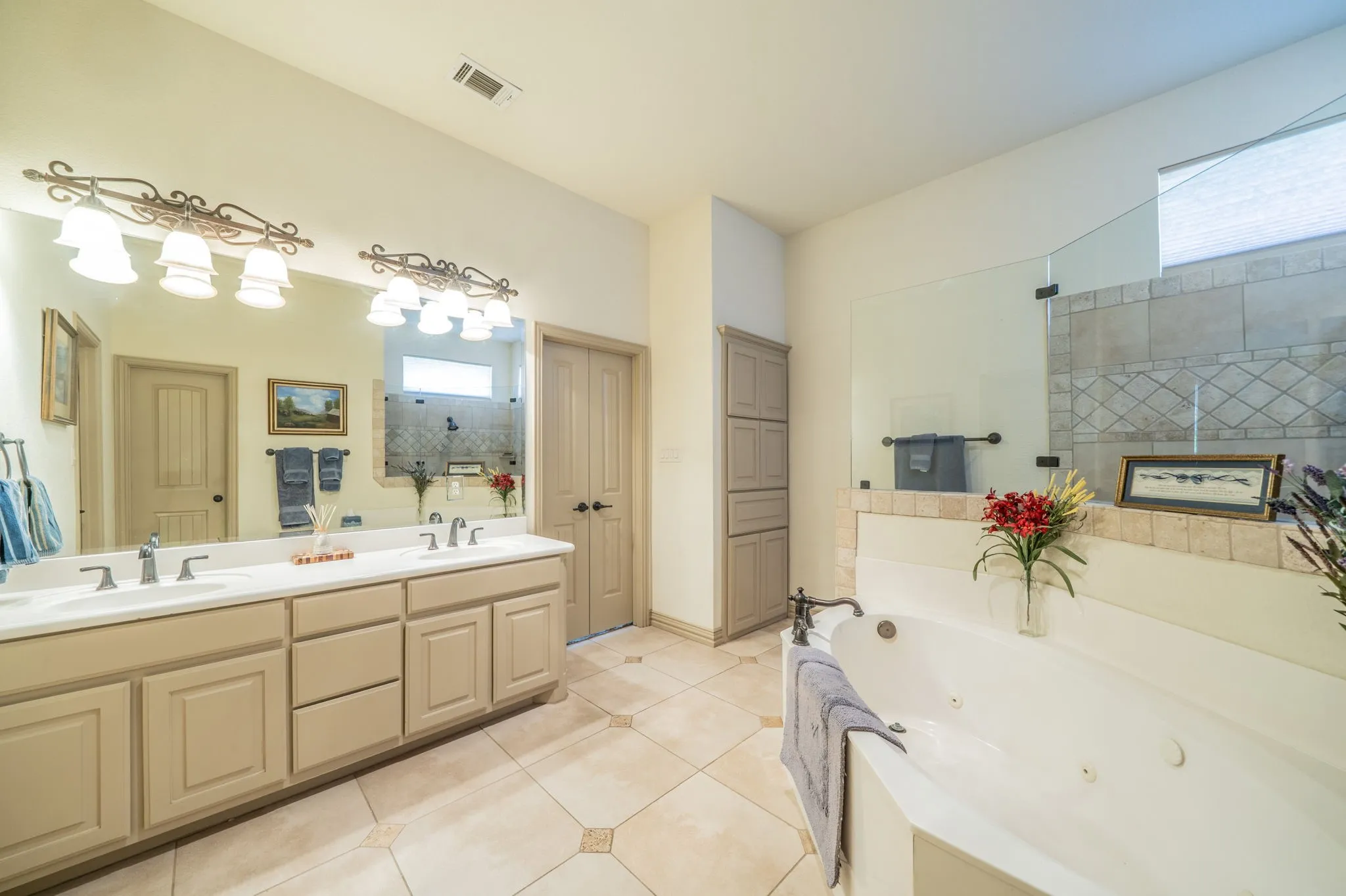 Double vanity with storage and jetted tub.