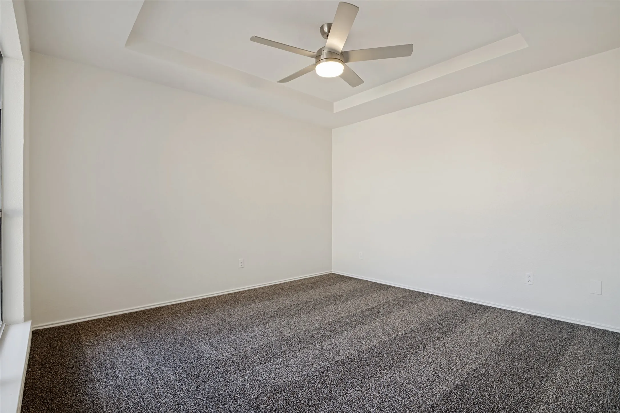 Tray ceiling with a modern ceiling fan and integrated lighting