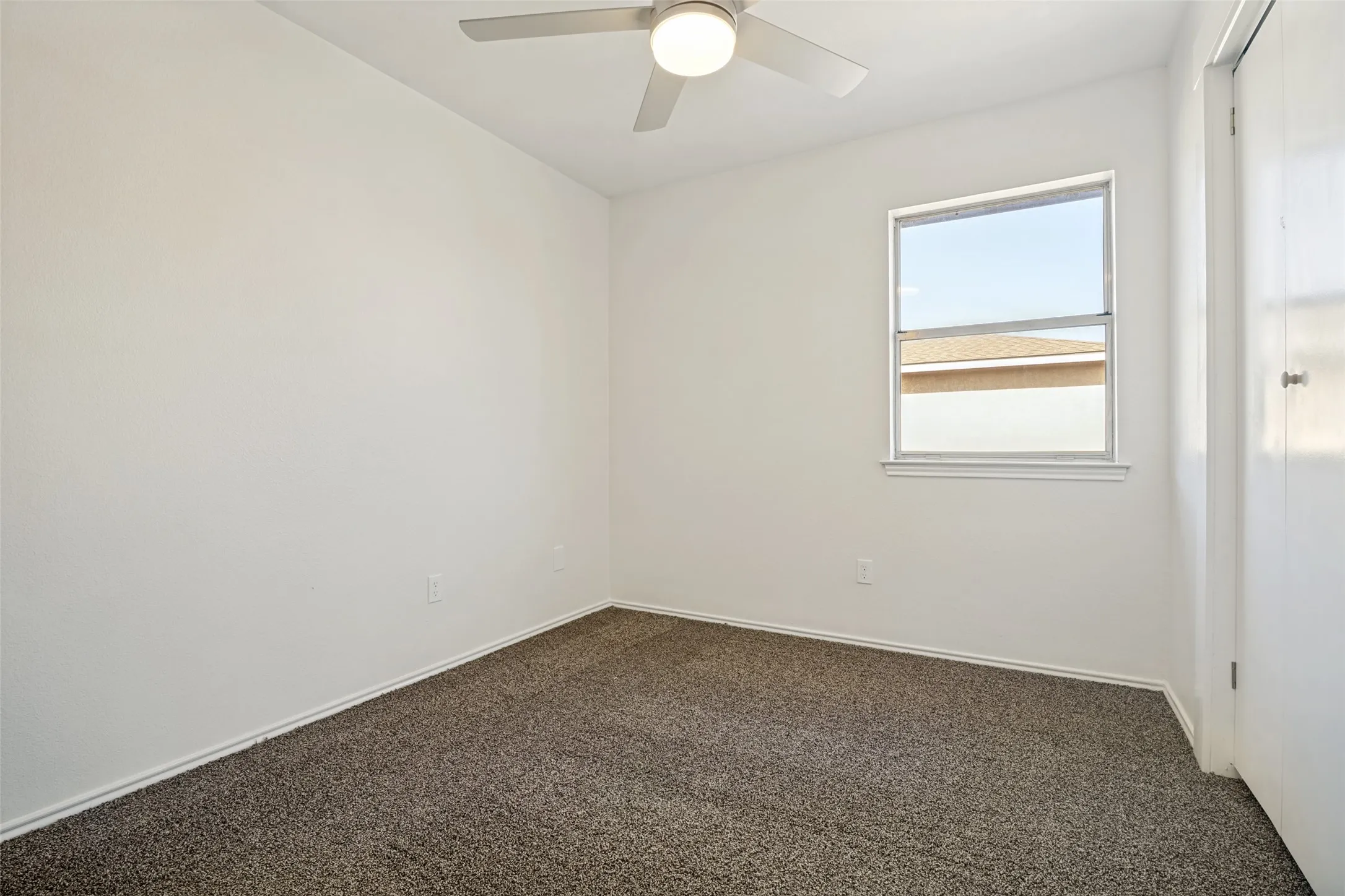Bedroom featuring light-colored walls and dark textured carpeting