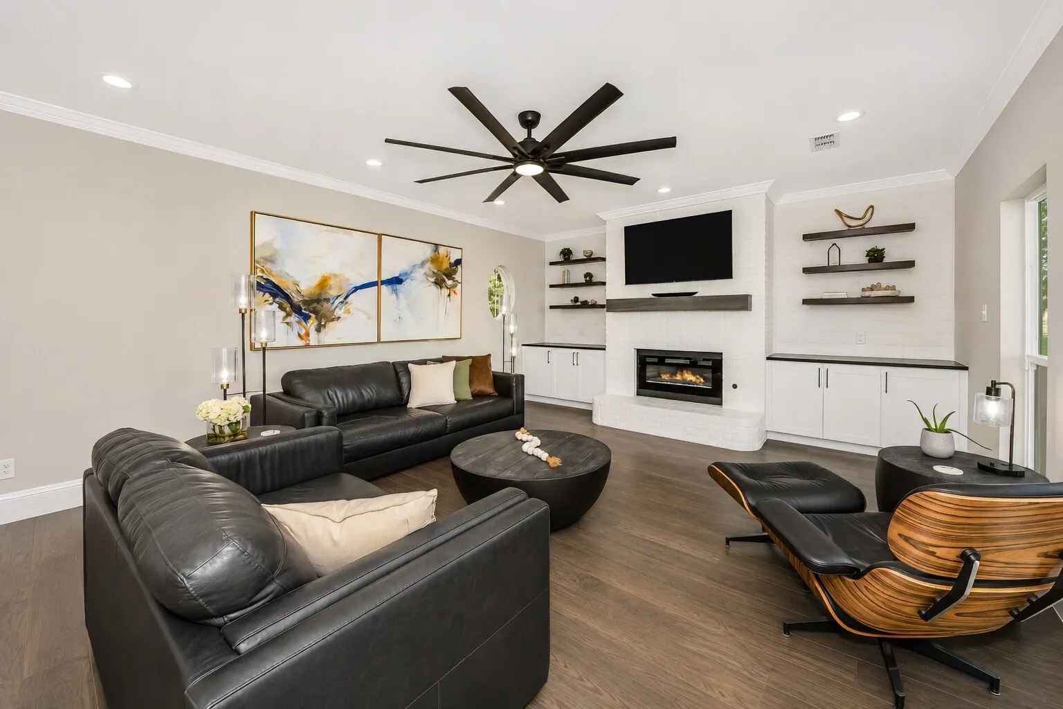 This angle shows how open and comfortable the living room feels, with deep built-ins framing the fireplace and plenty of space for seating. The layout keeps everything centered around the views at the back of the home, giving the room a bright, relaxed feel. It’s a modern, easy-to-live-in space that works just as well for quiet evenings as it does for hosting.