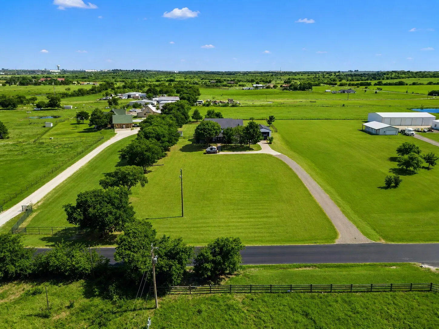 South View-Shows the full rear fence line, east and west boundaries, and the southern landscape extending beyond the property.