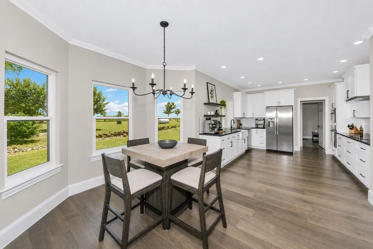 The breakfast nook sits right between the kitchen and living room, surrounded by windows that open to breathtaking views of the backyard and the landscape beyond. It’s a bright, easy spot for morning coffee, casual meals, or simply taking in the scenery. The layout keeps the space connected to the heart of the home while still feeling calm and tucked away.