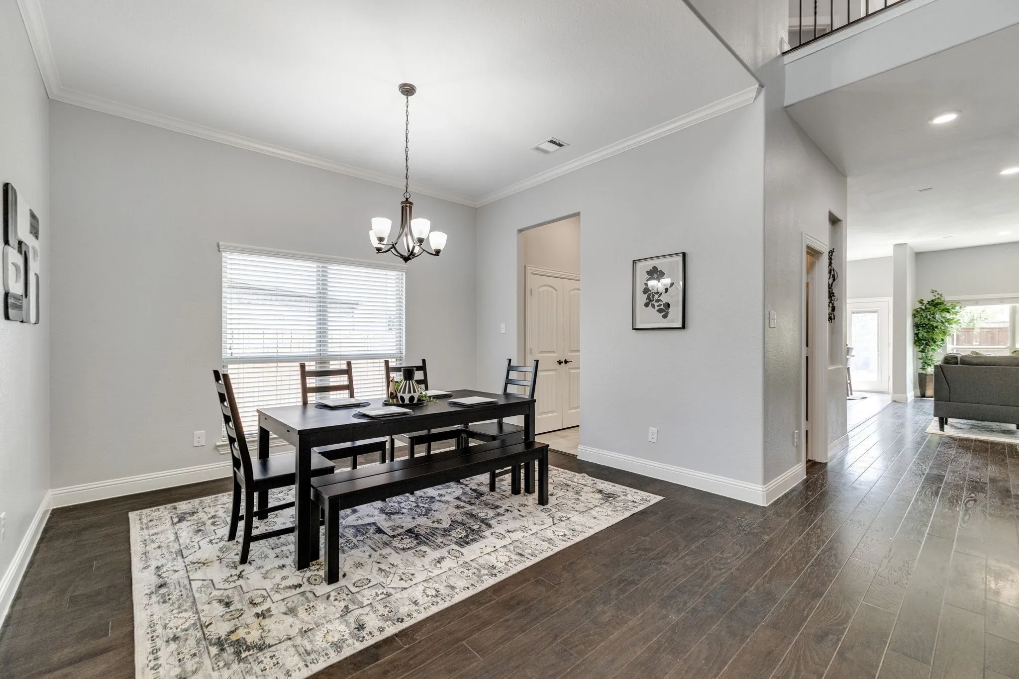 Dining area featuring dark wood-finish flooring, light gray walls, and white crown molding