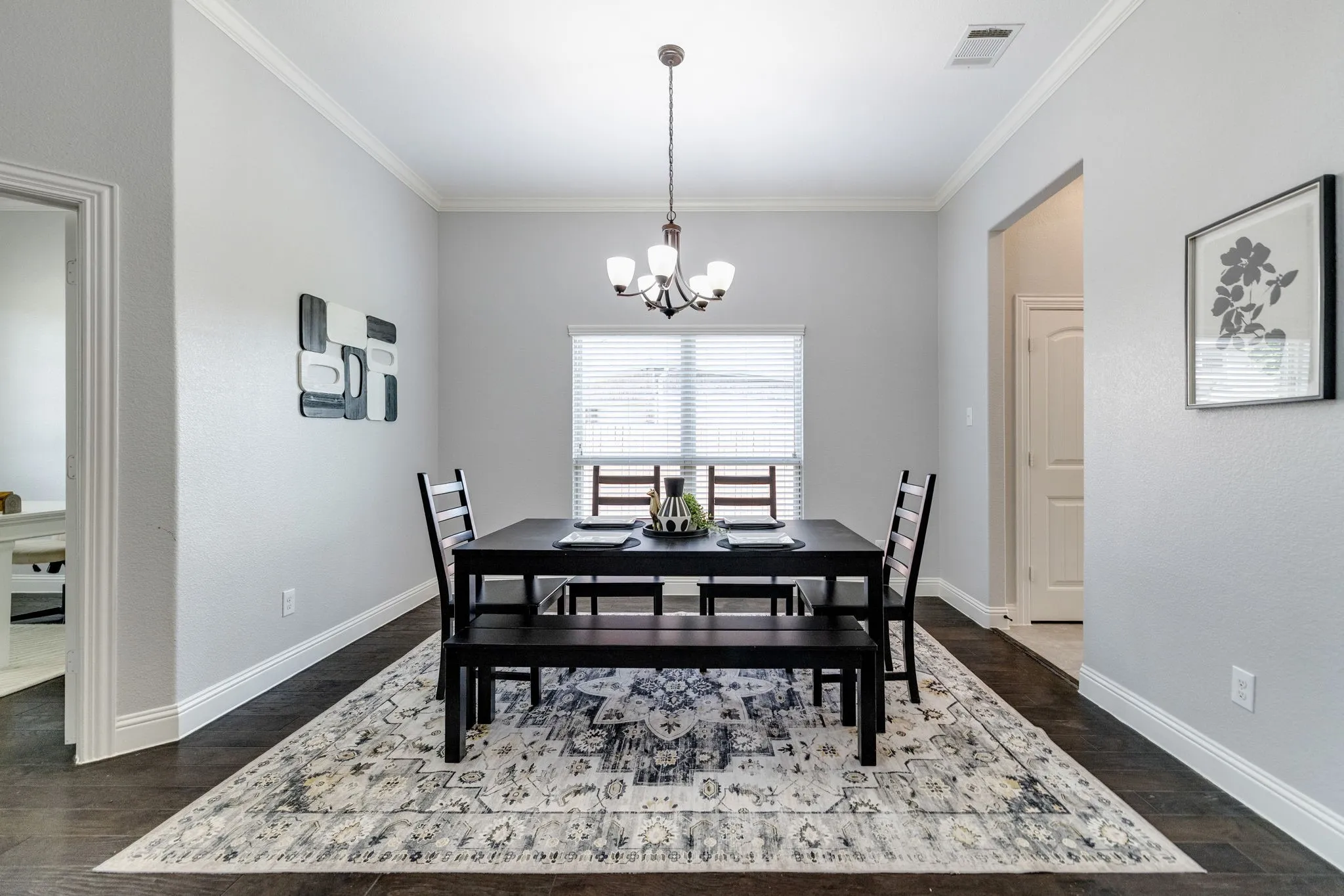 Dining area featuring wood-finish flooring, light gray wall paint, and white crown molding