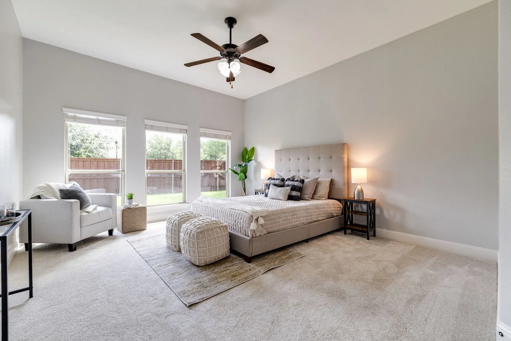 Spacious room featuring vaulted ceilings, a ceiling fan with light kit, and three large windows