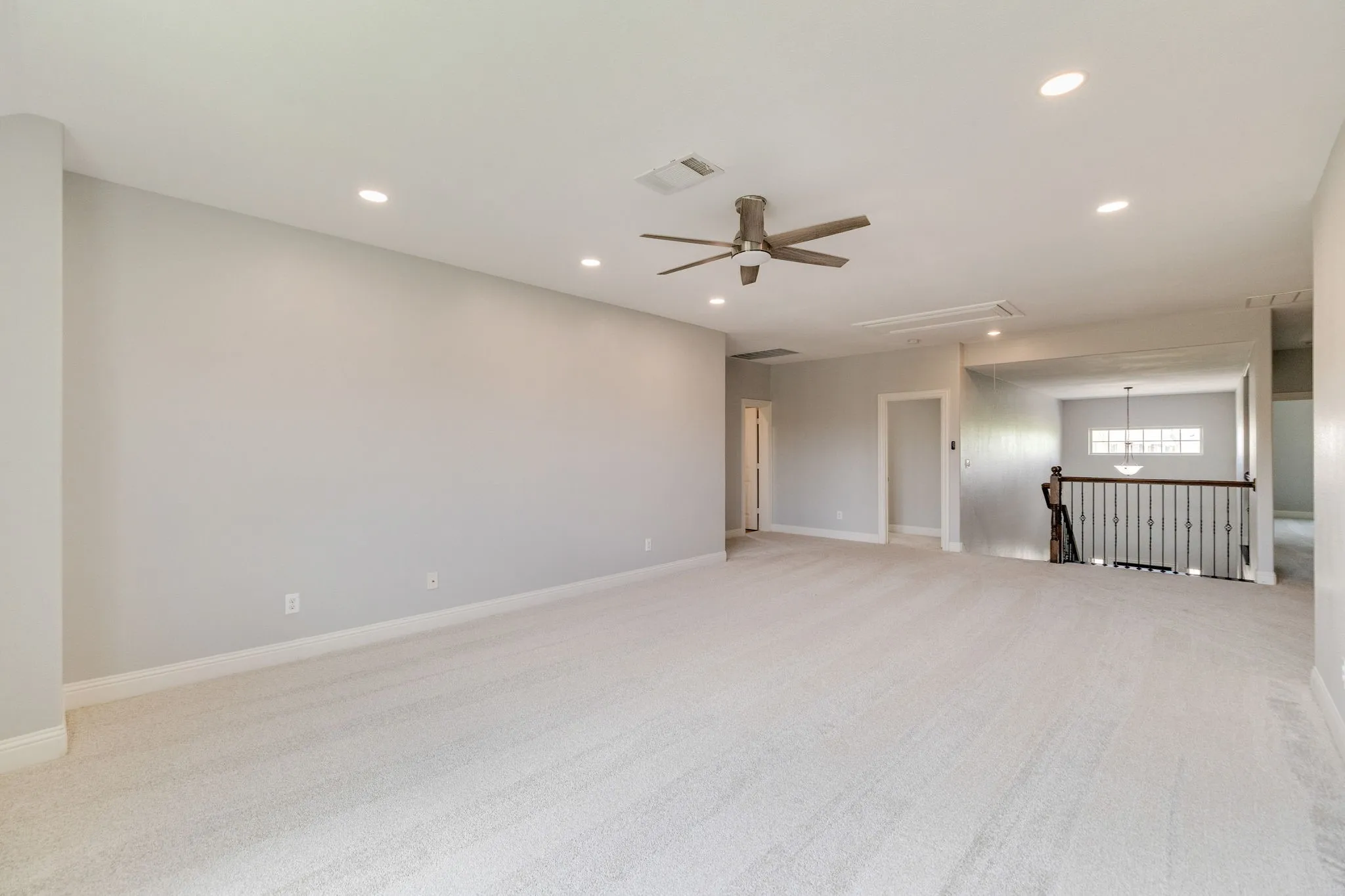 Expansive carpeted room featuring recessed lighting, a ceiling fan, and light gray wall paint