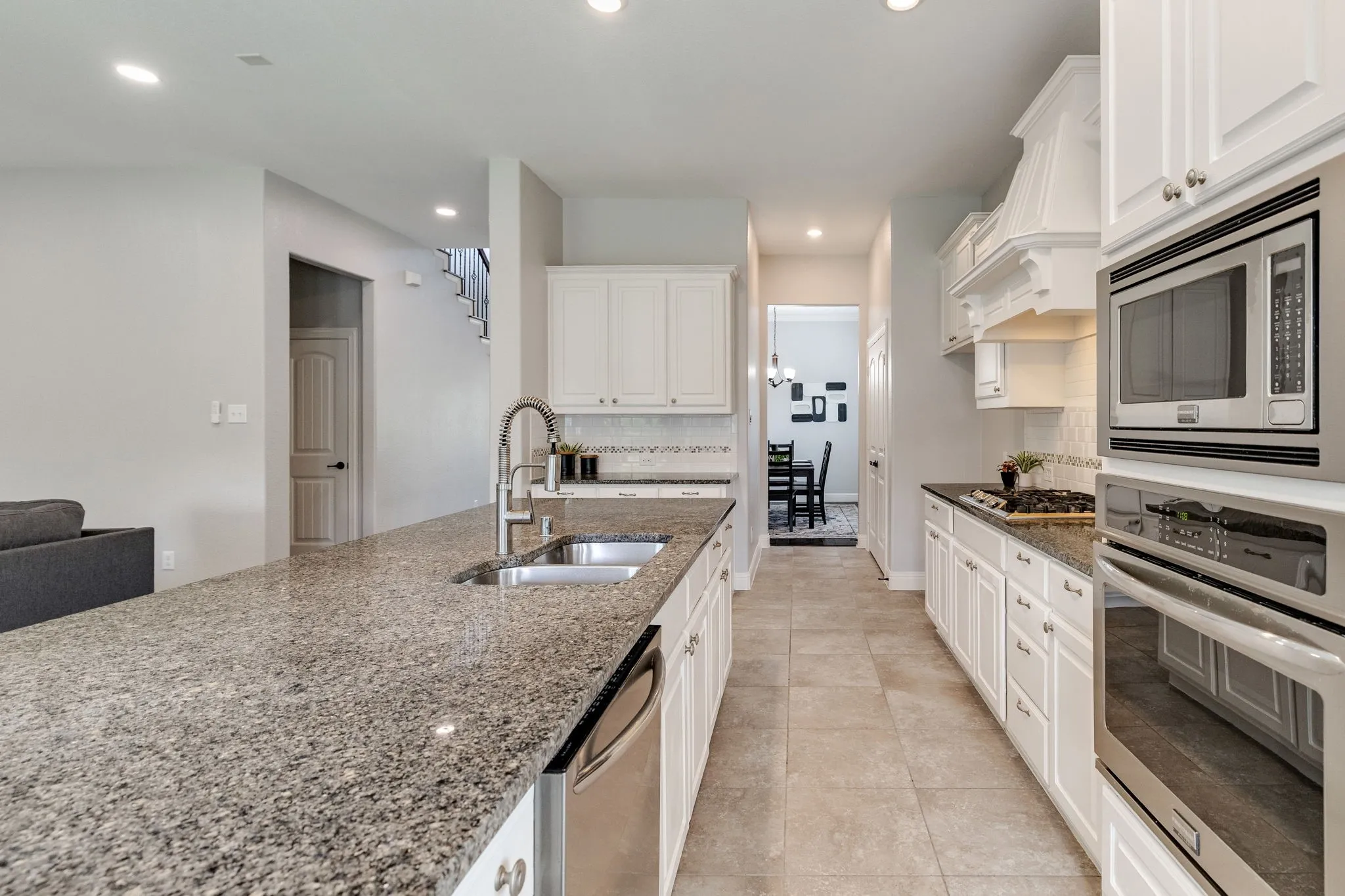 Kitchen featuring an expansive island with a double sink and stainless steel dishwasher