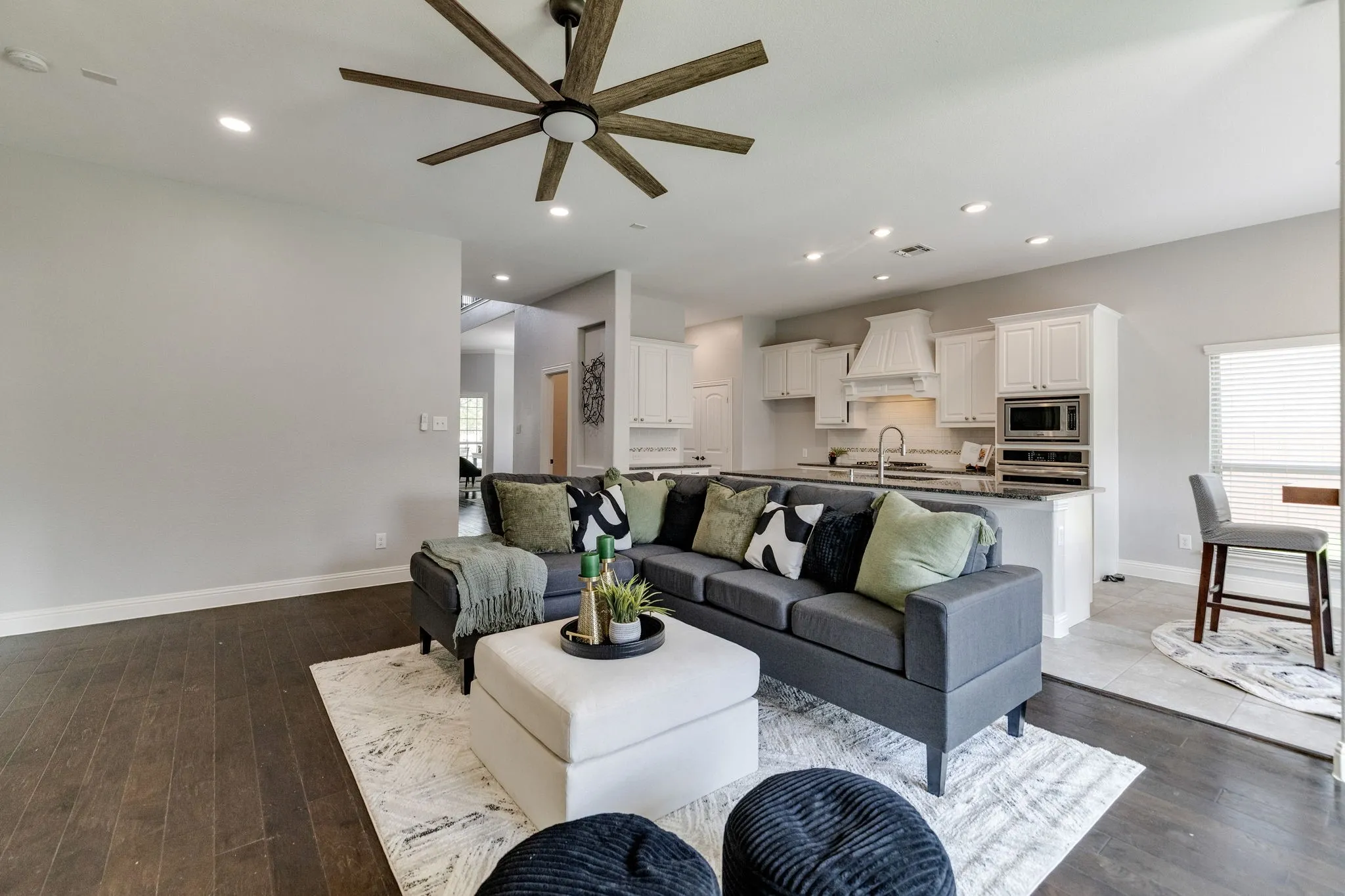 Open-concept living space featuring wood-finish flooring, recessed lighting, and a contemporary ceiling fan