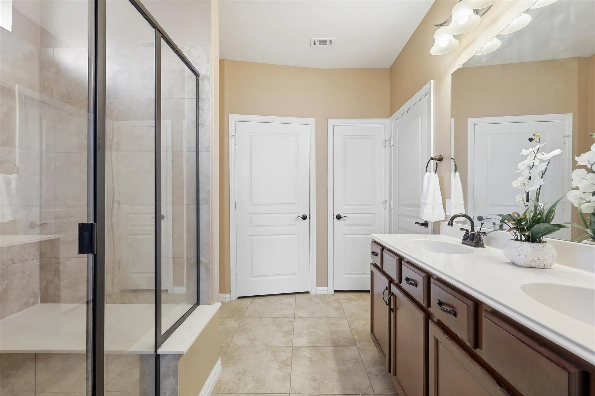 Spa-like primary bathroom with dual vanities, ample counter space, and a clean, modern feel.