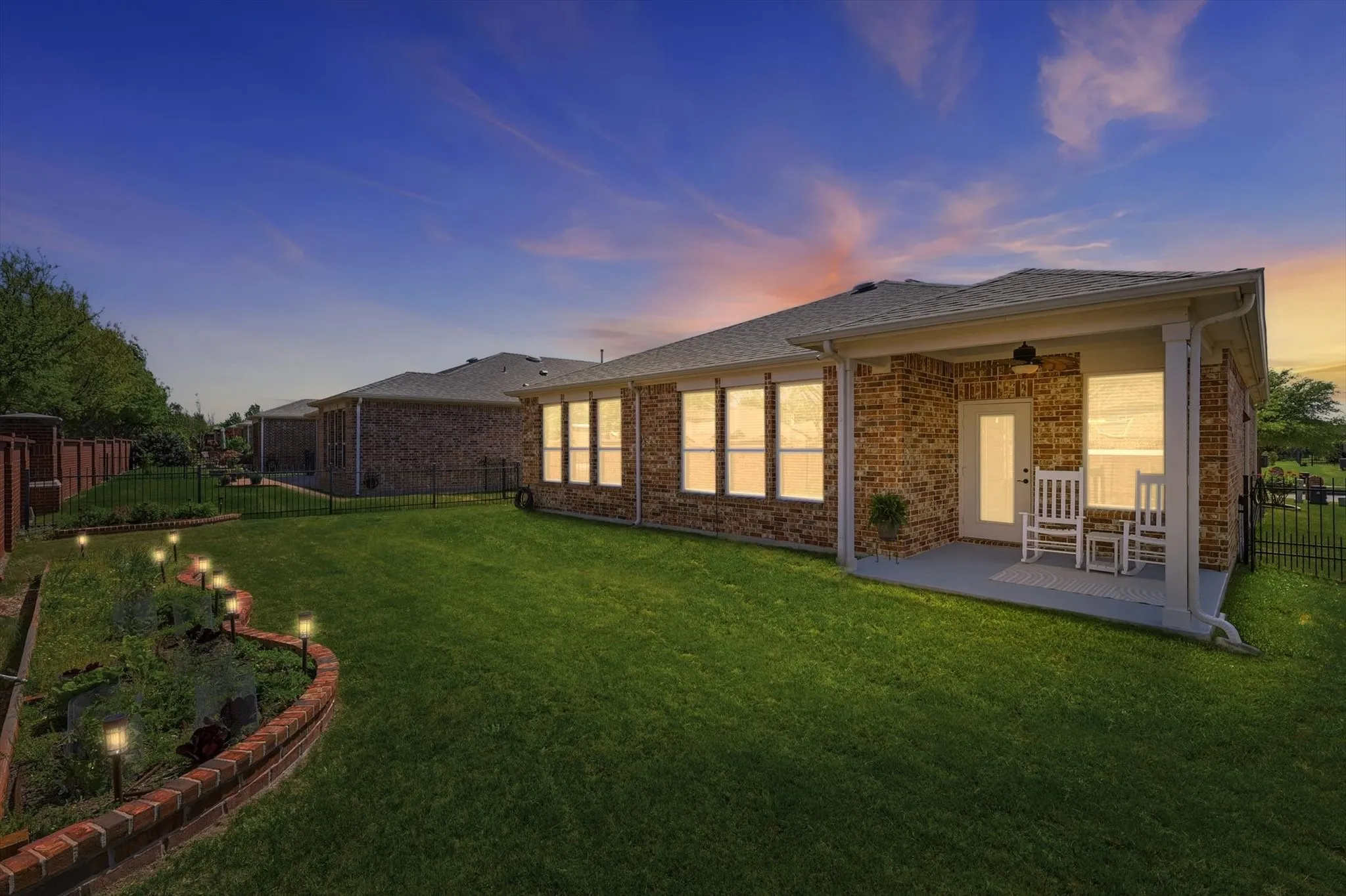 Evening view of the backyard creates a cozy and peaceful outdoor ambiance.