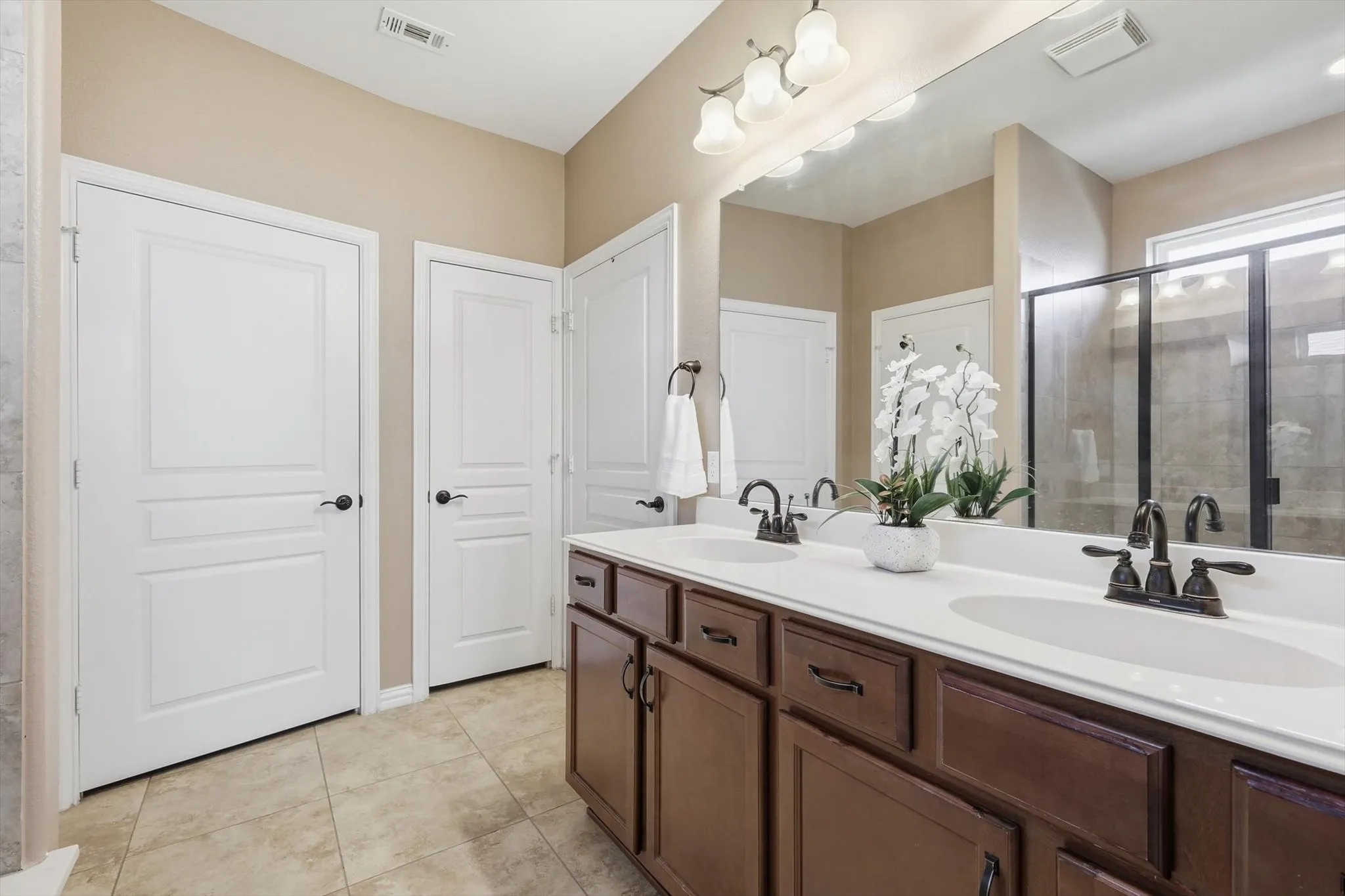 Spacious primary bathroom with dual sinks and plenty of storage for convenience.